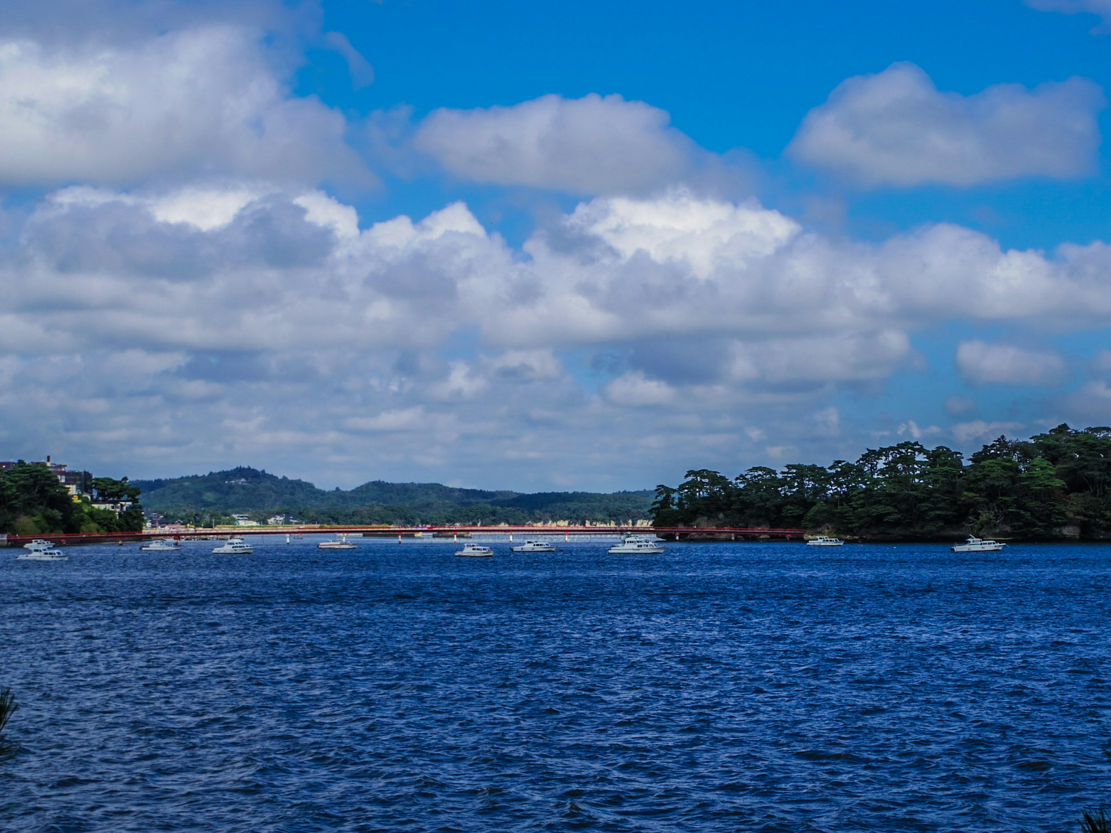 Vue panoramique de l'eau bleue avec des nuages blancs des îles et des bateaux visibles