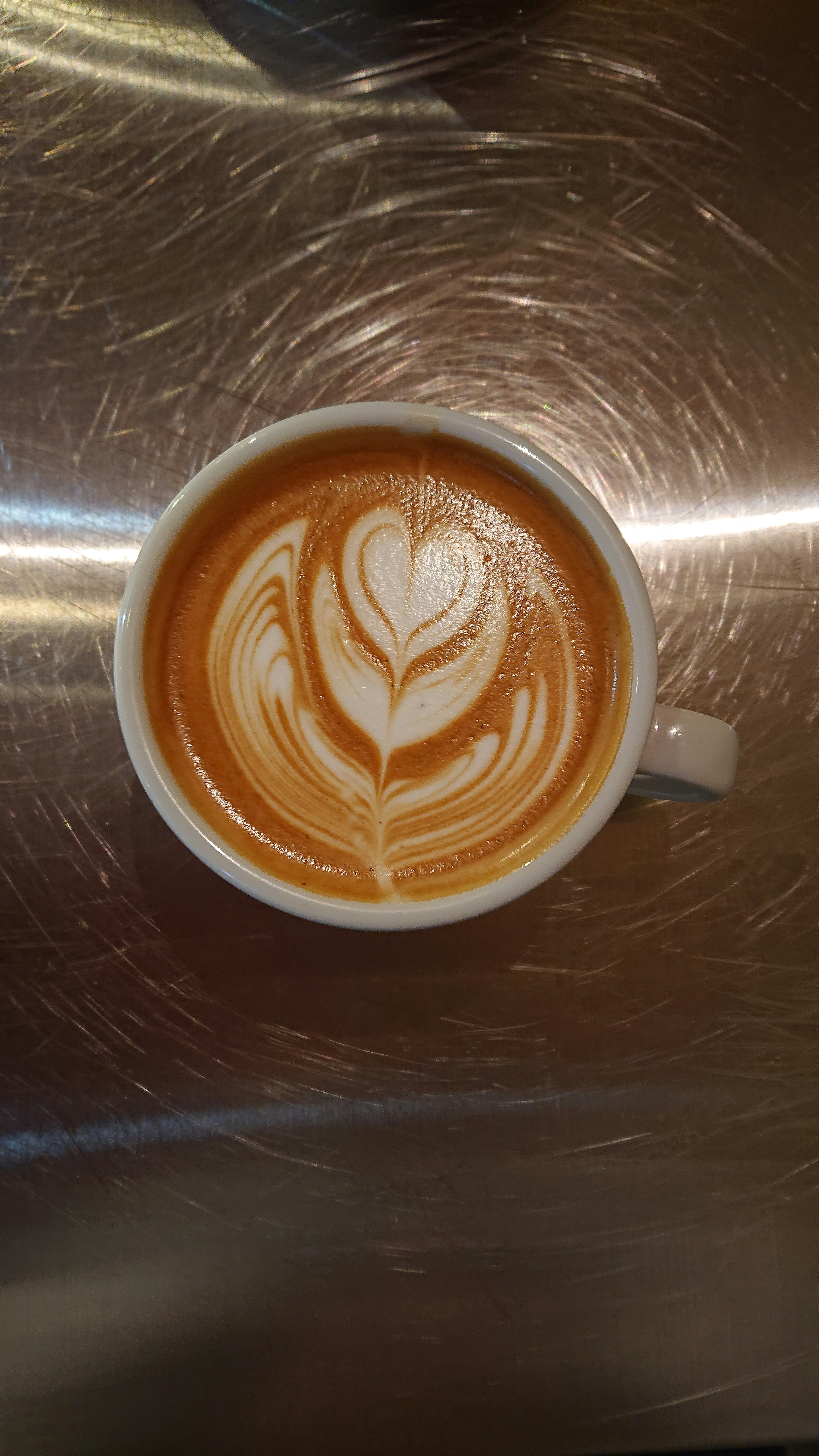 Taza de arte latte con un hermoso diseño en forma de corazón