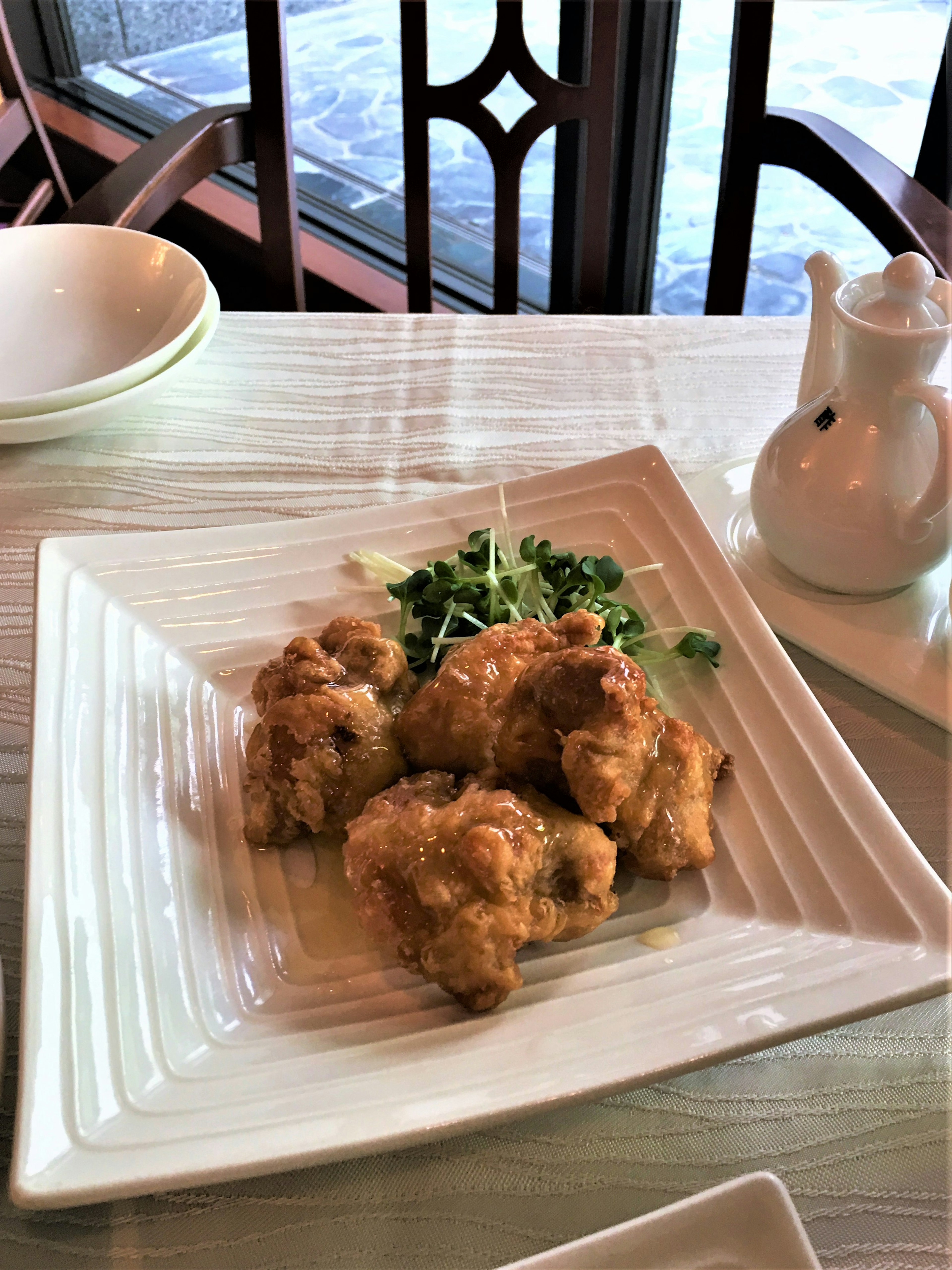 Fried dish served on a white plate with green herbs