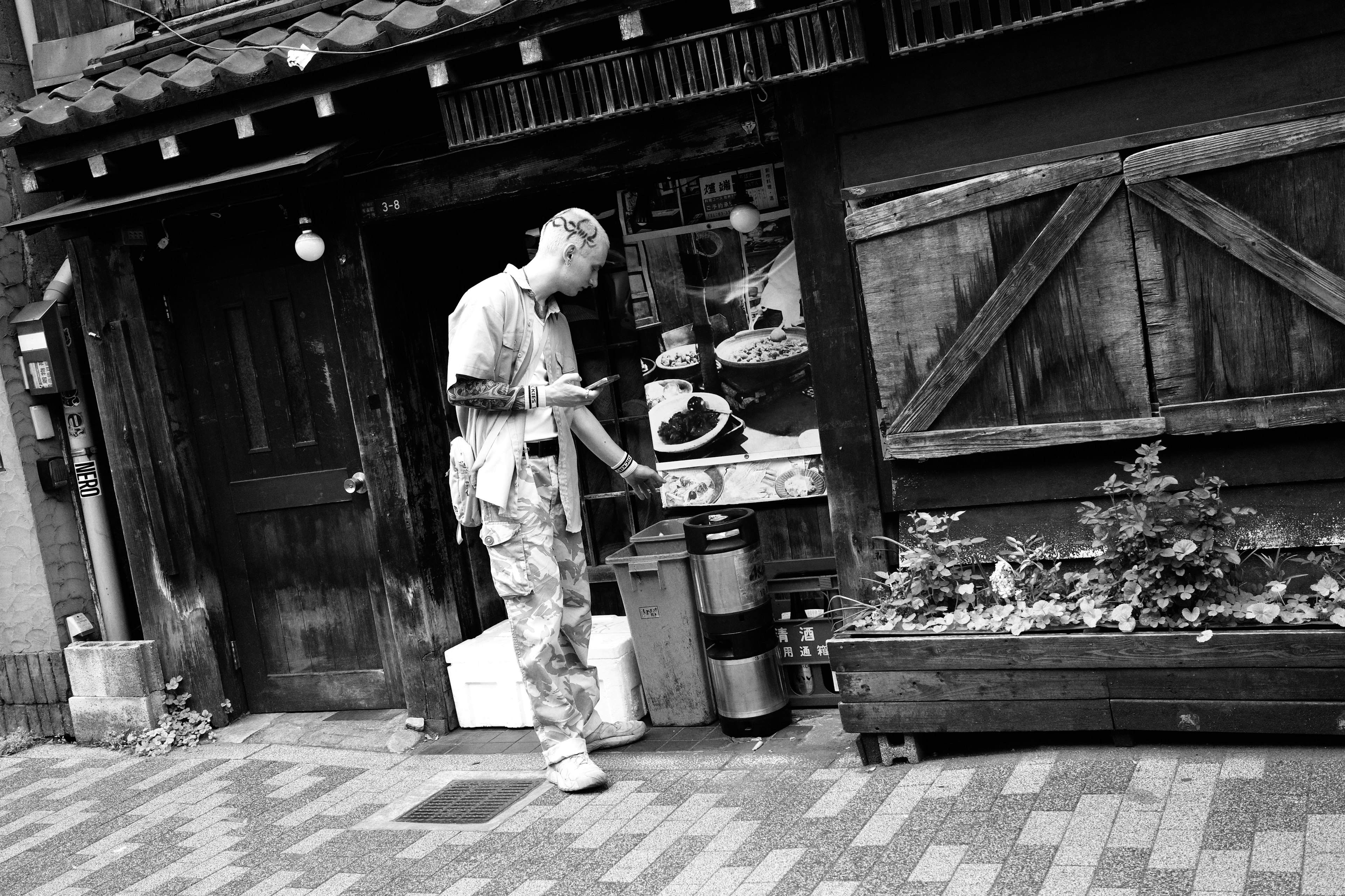 Man working in a black and white street scene with an old building