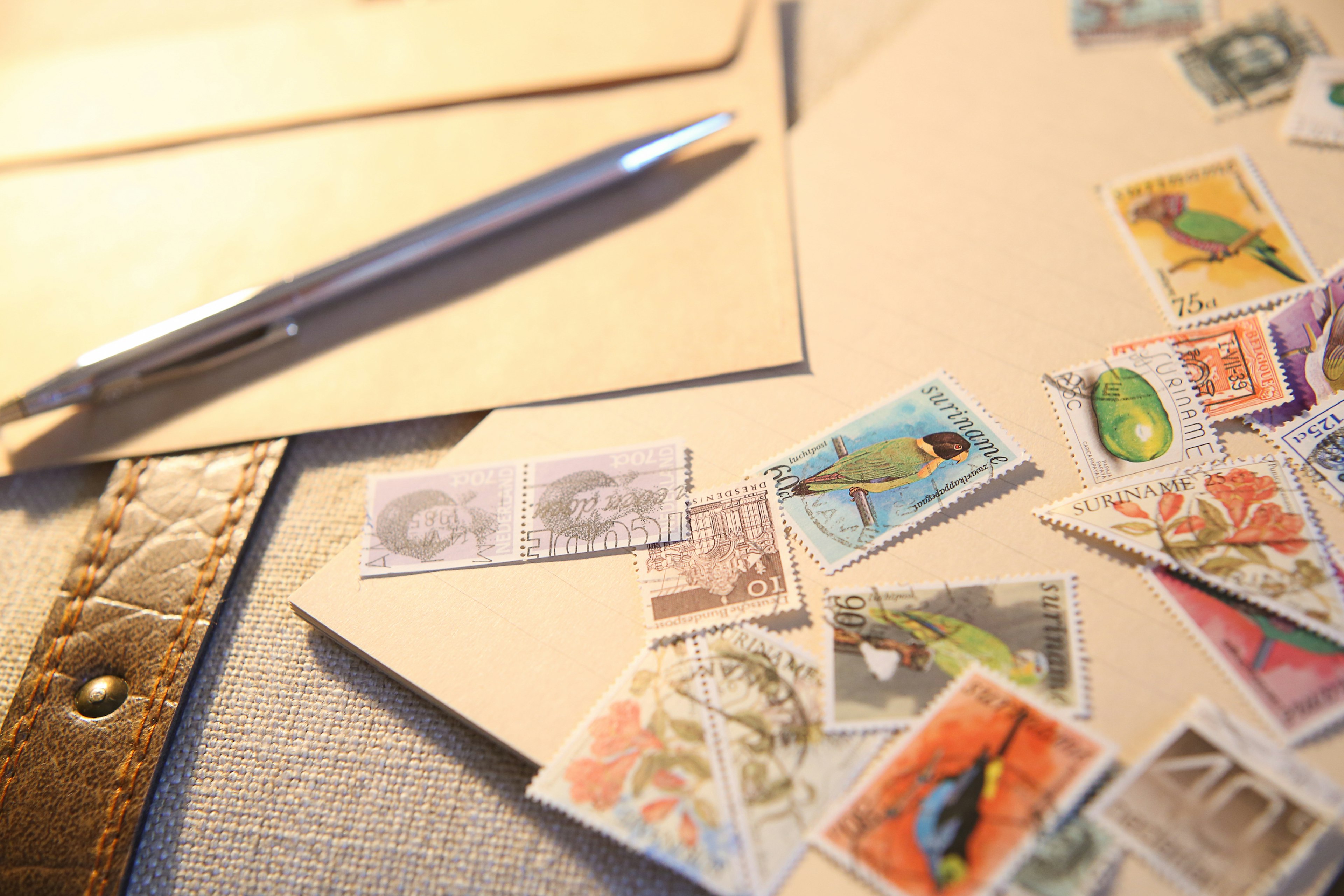 A desk scene with scattered letters and colorful stamps