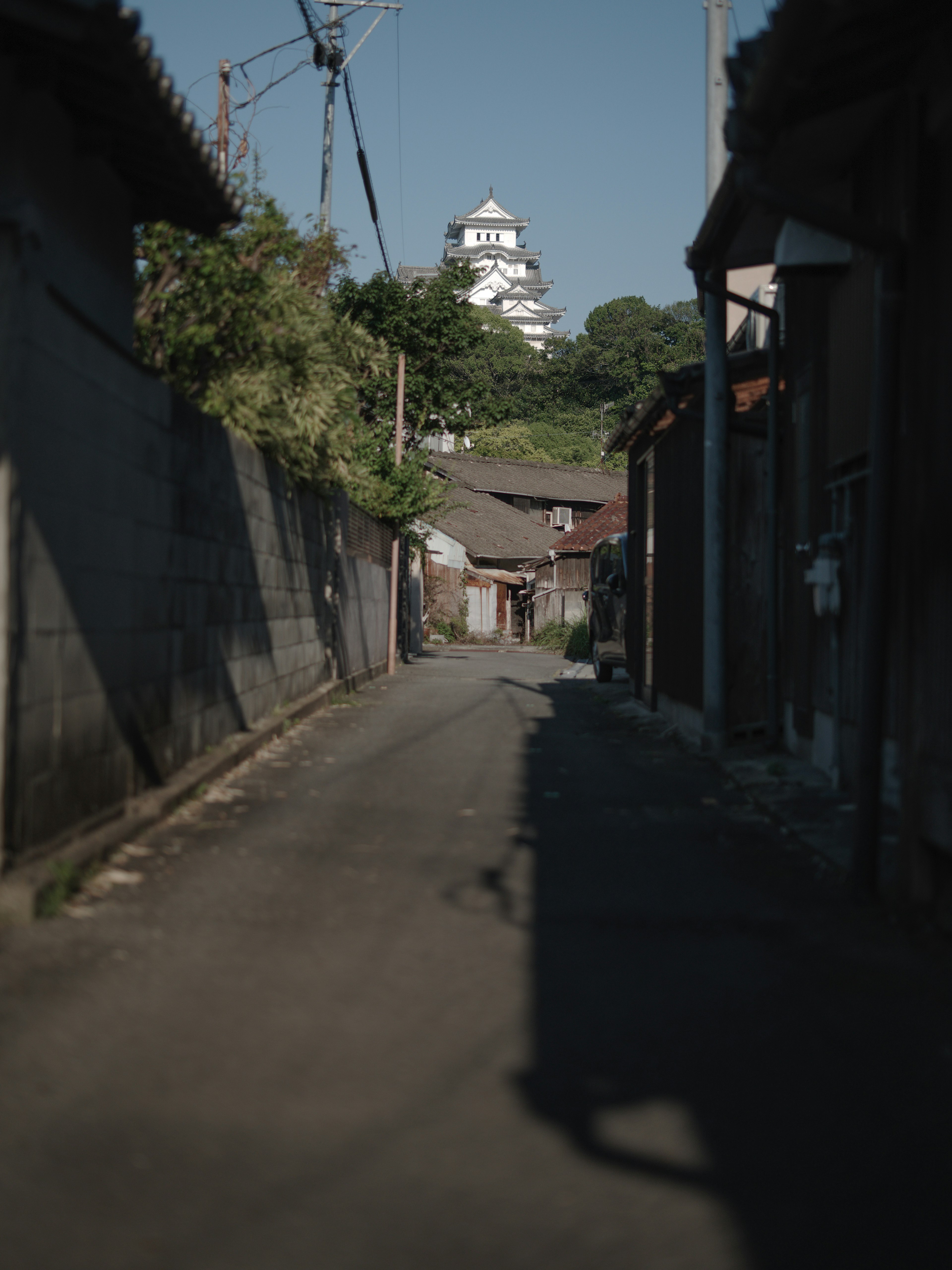 Schmaler Weg mit alten Gebäuden und einem fernen Schloss-Turm