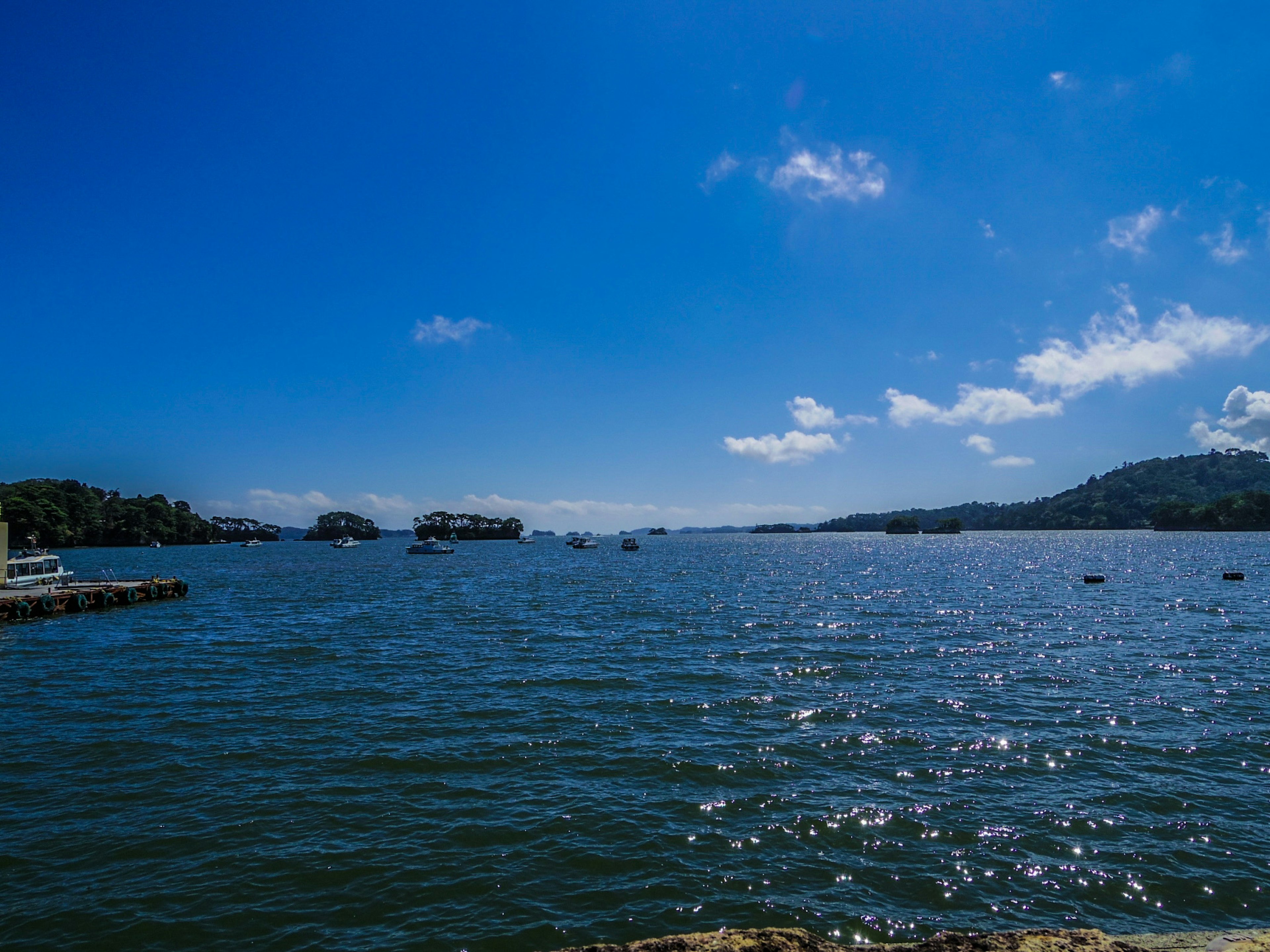 Vue panoramique d'un ciel bleu et d'une eau scintillante avec des bateaux et des îles