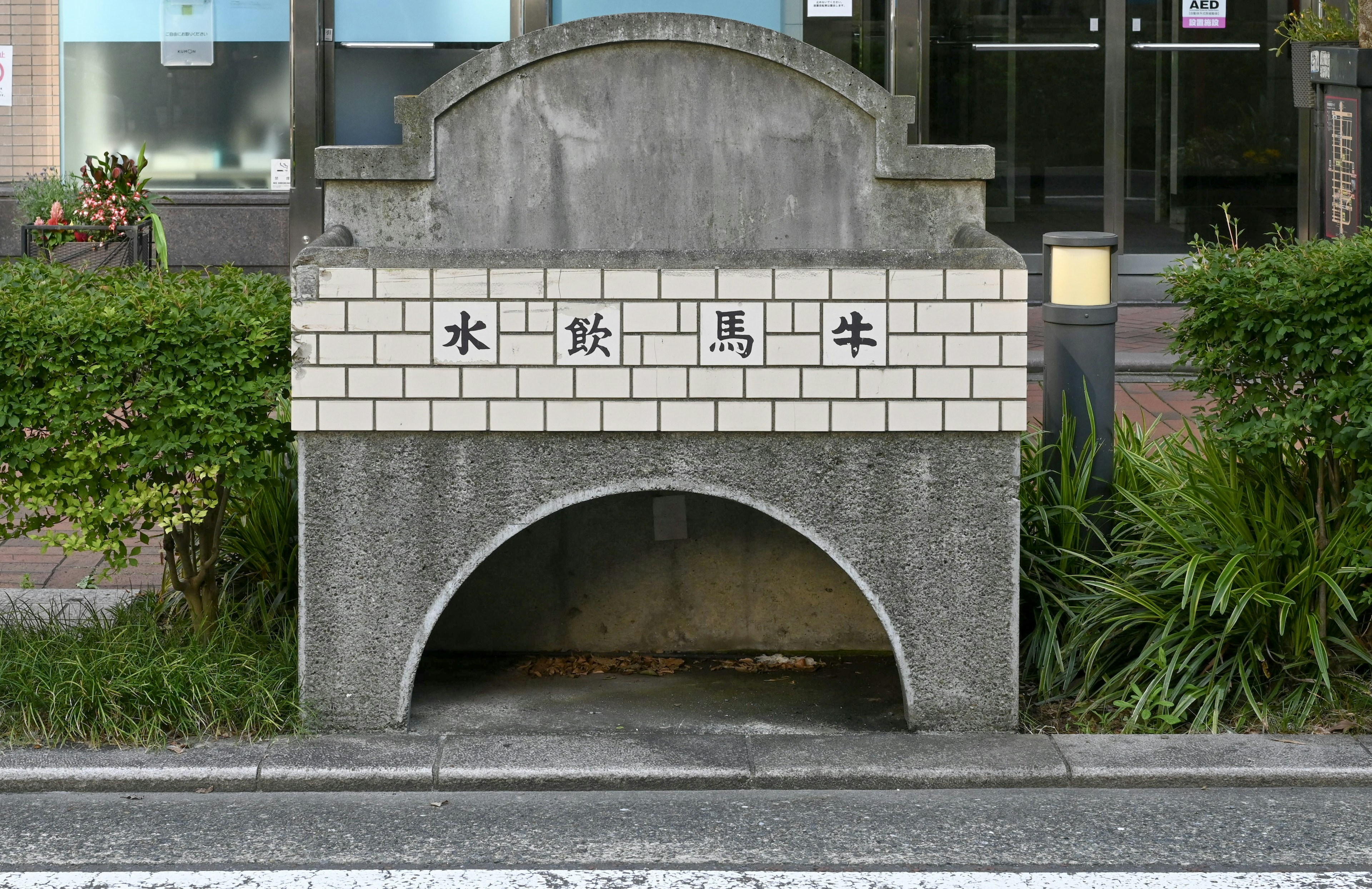 Estructura de concreto para drenaje de agua con señalización en japonés