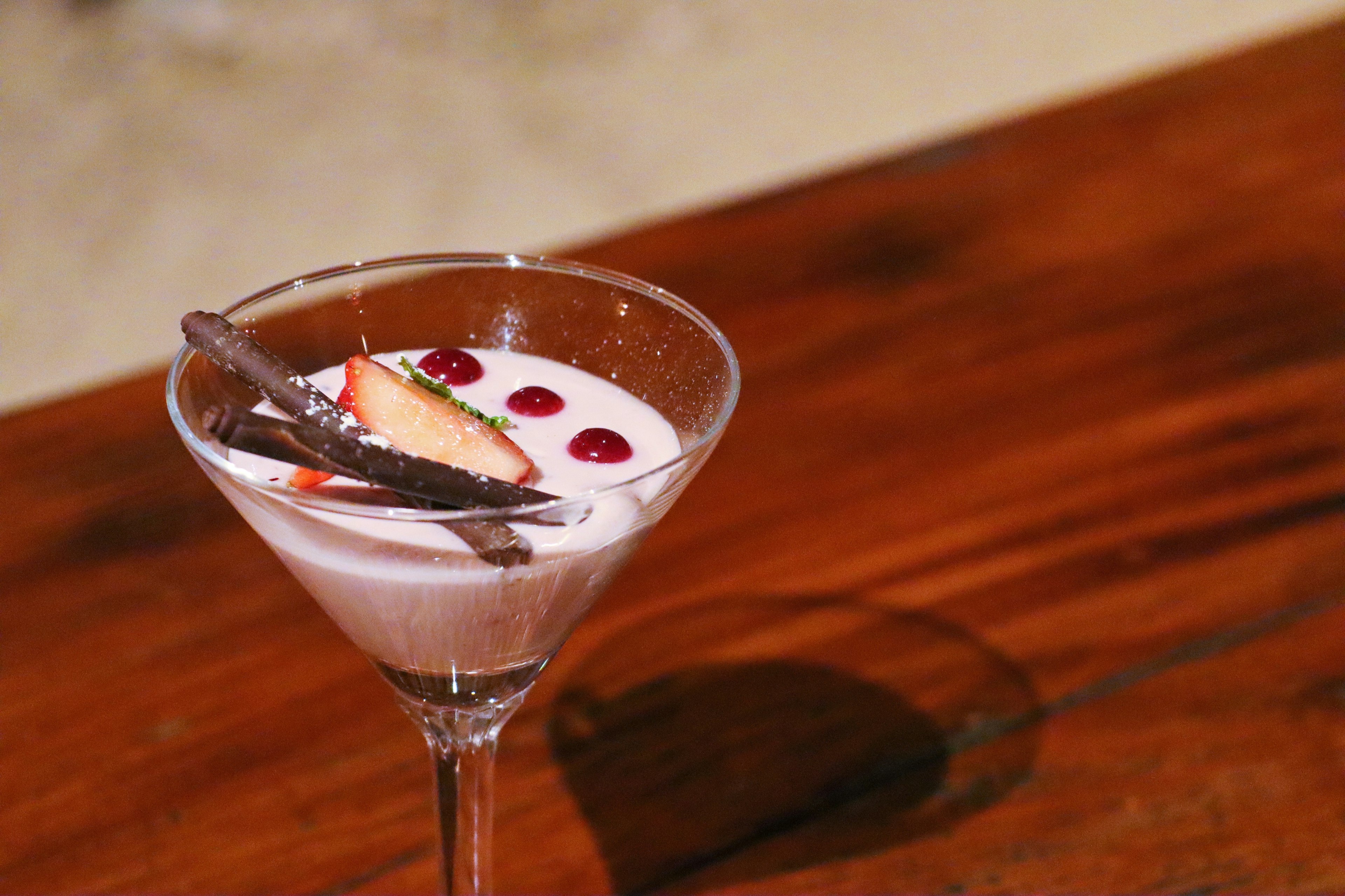 Cocktail glass with creamy drink and fruit toppings