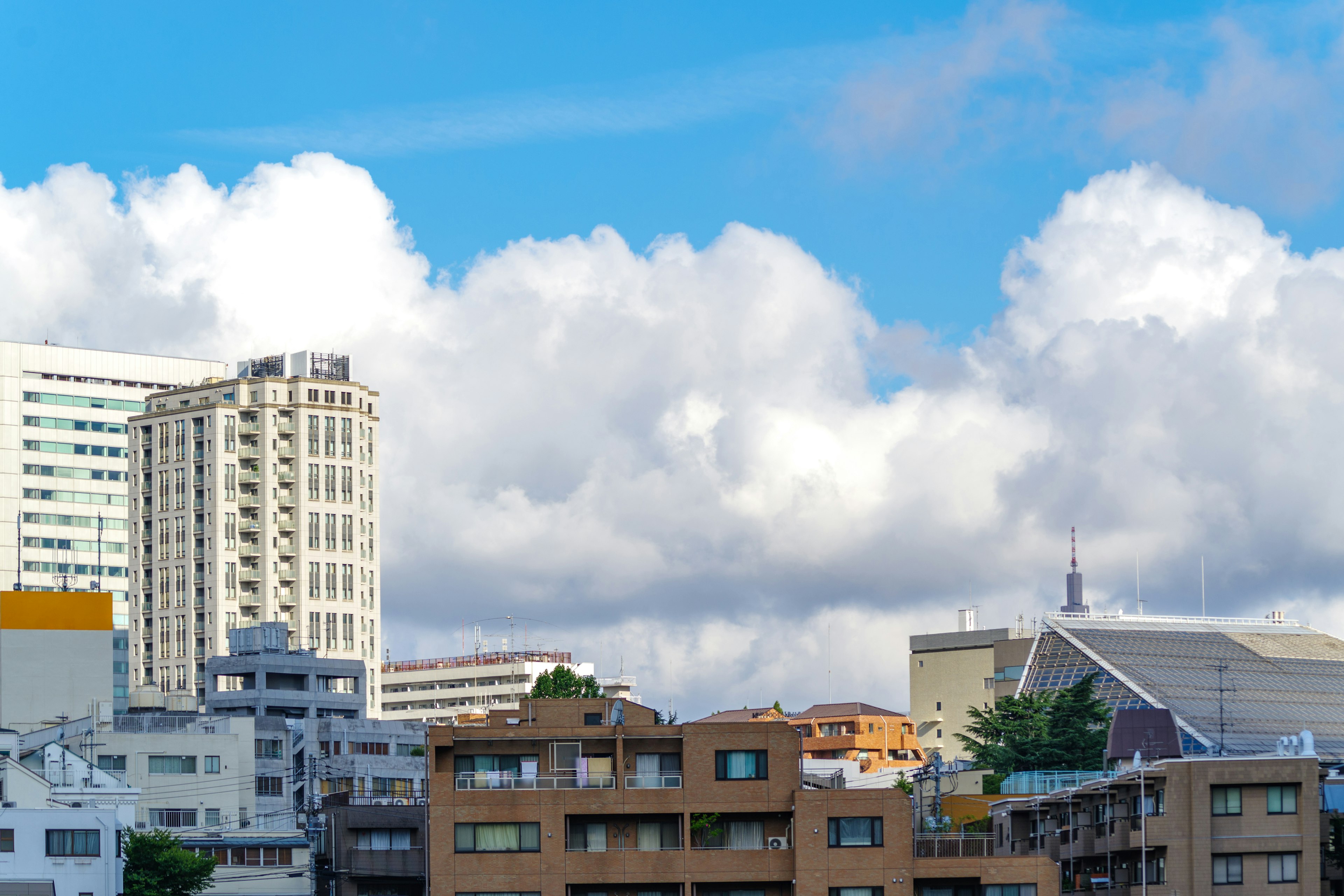 青空の下に広がる都市景観 高層ビルと雲が特徴