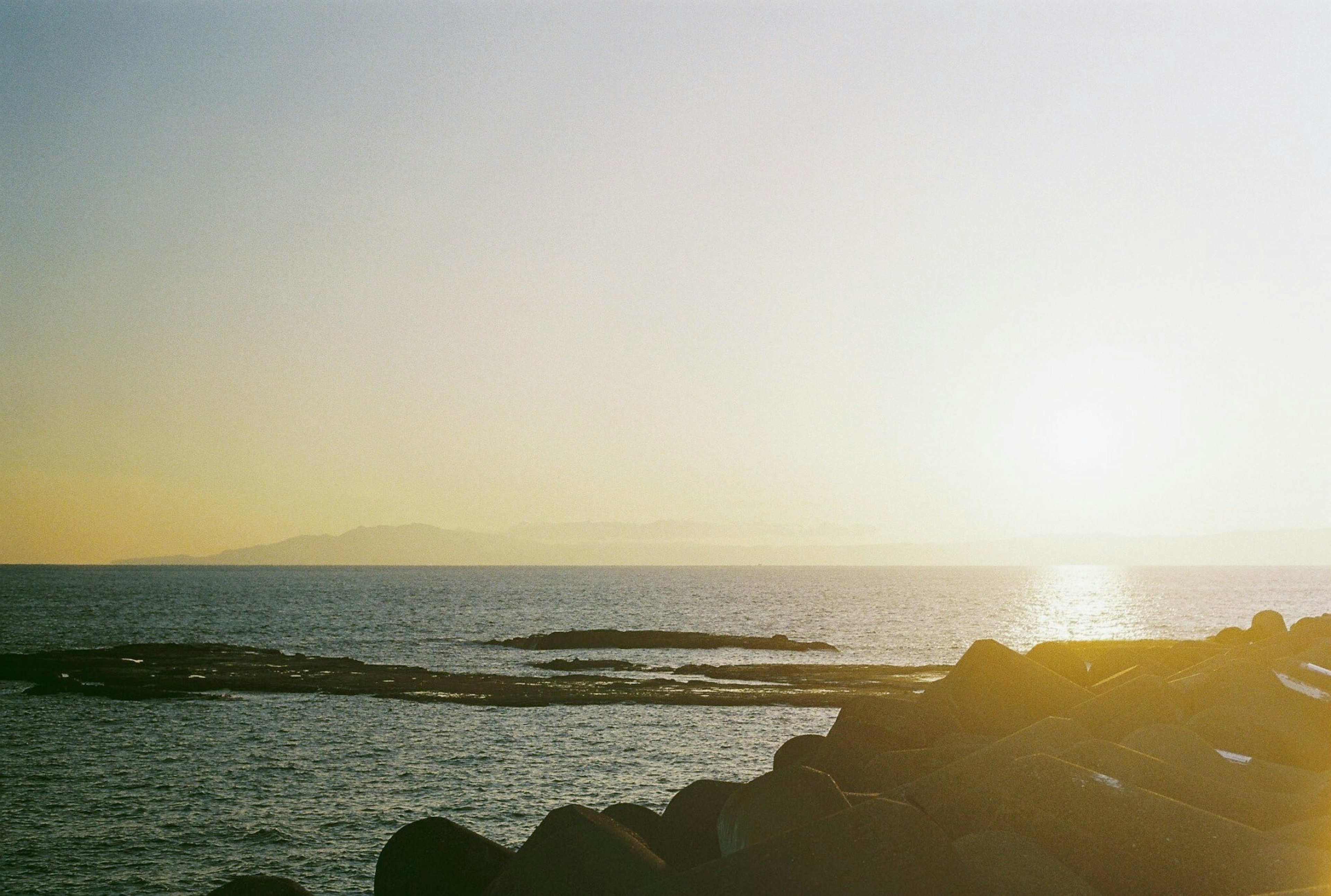 Scenic view of the ocean and island at sunset