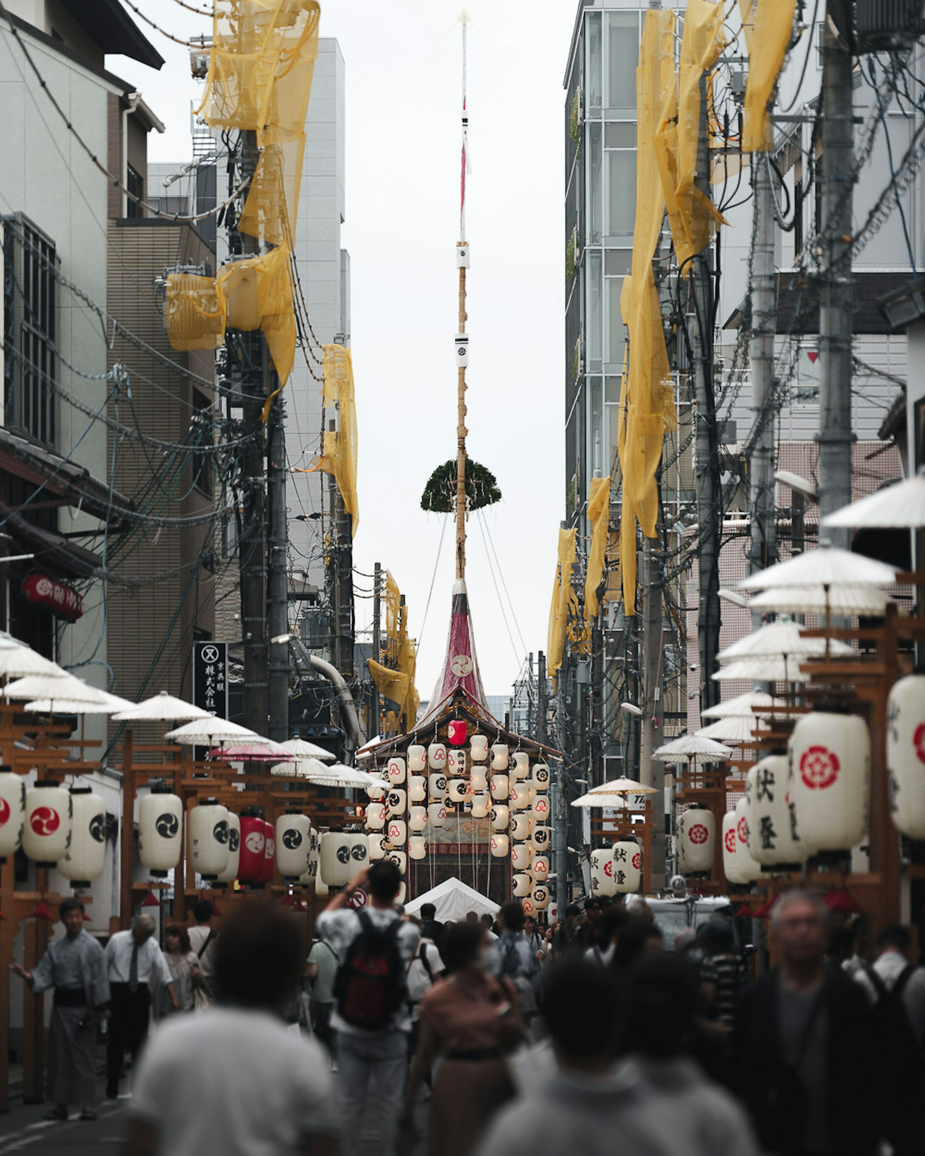 Belebte japanische Einkaufsstraße mit Laternen und gelben Dekorationen