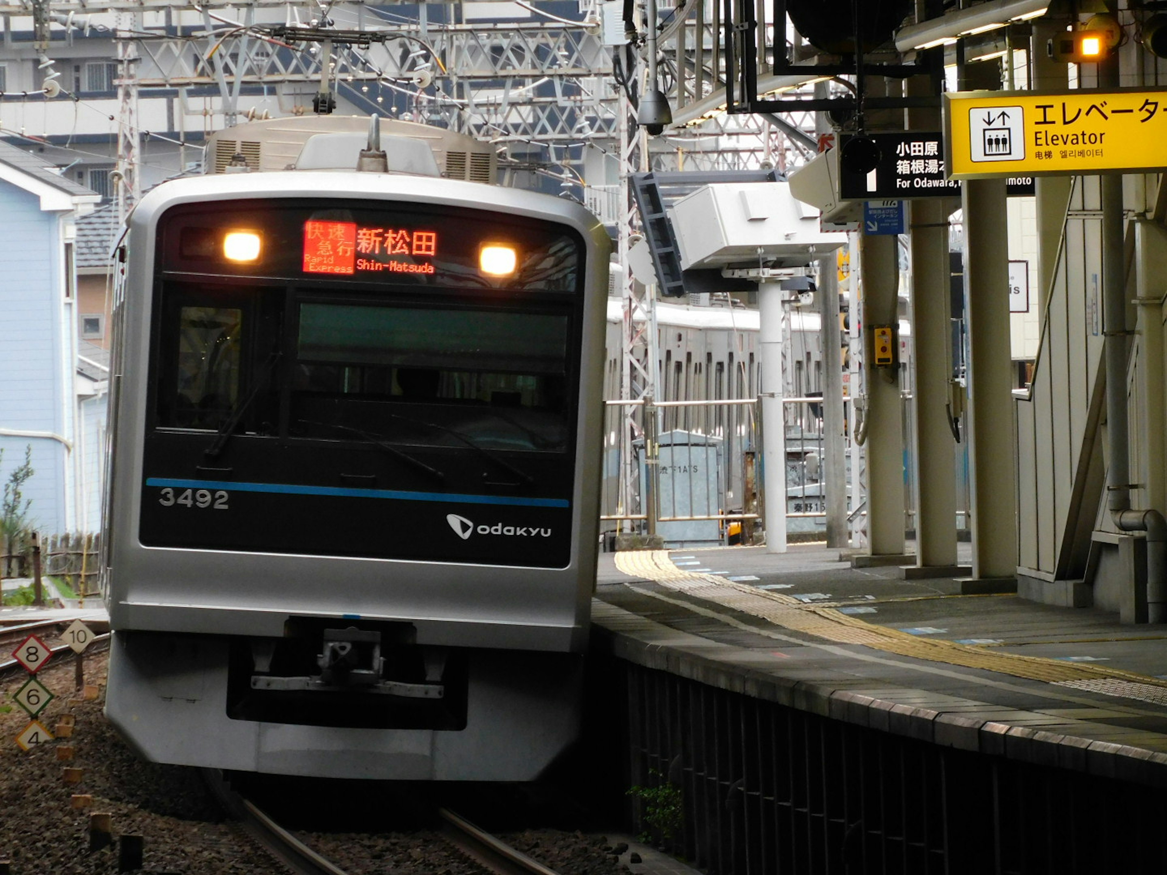 Train s'approchant de la gare avec un panneau indiquant la destination