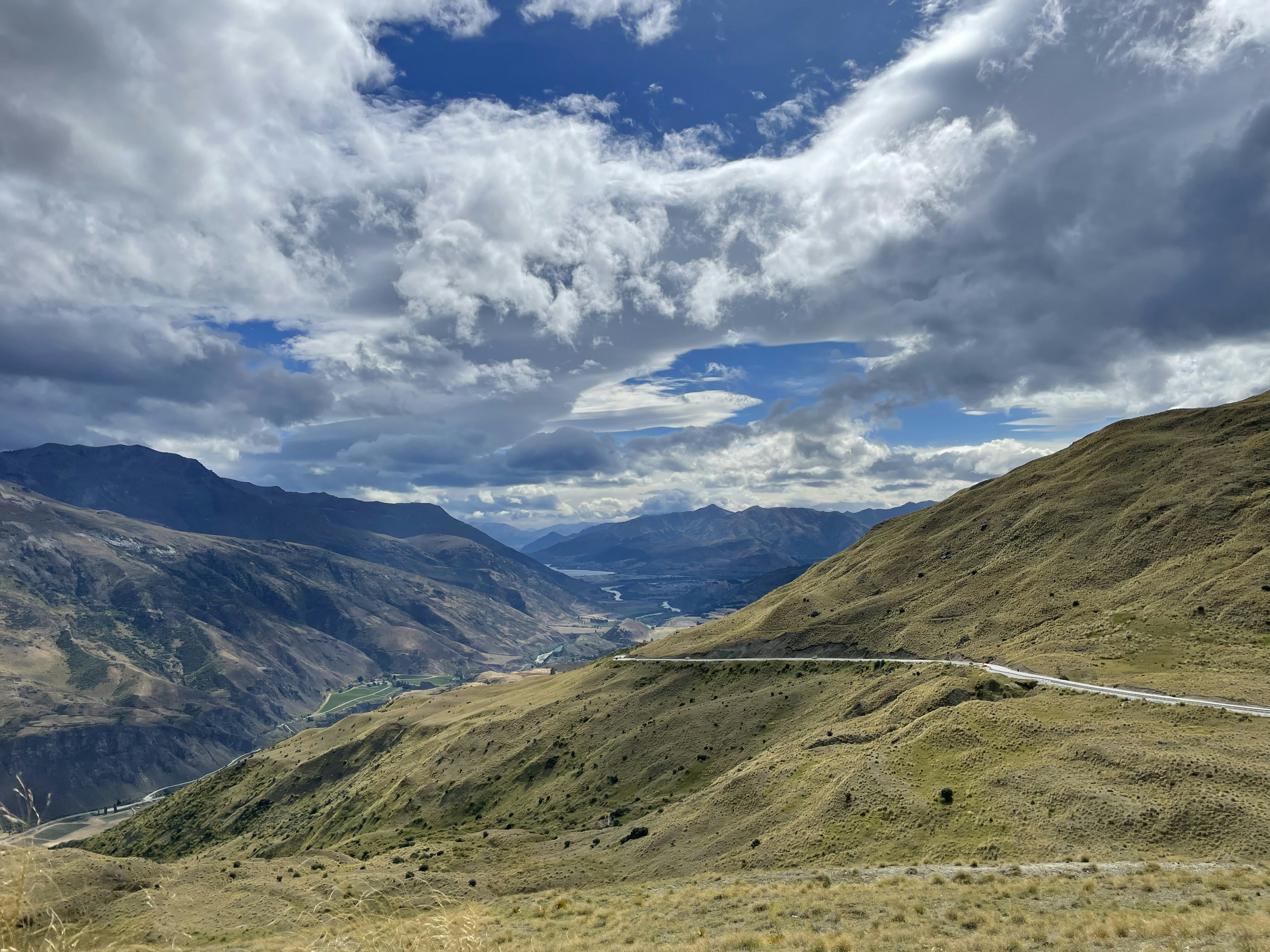 Paesaggio montano con cielo blu e nuvole colline verdi e strada tortuosa