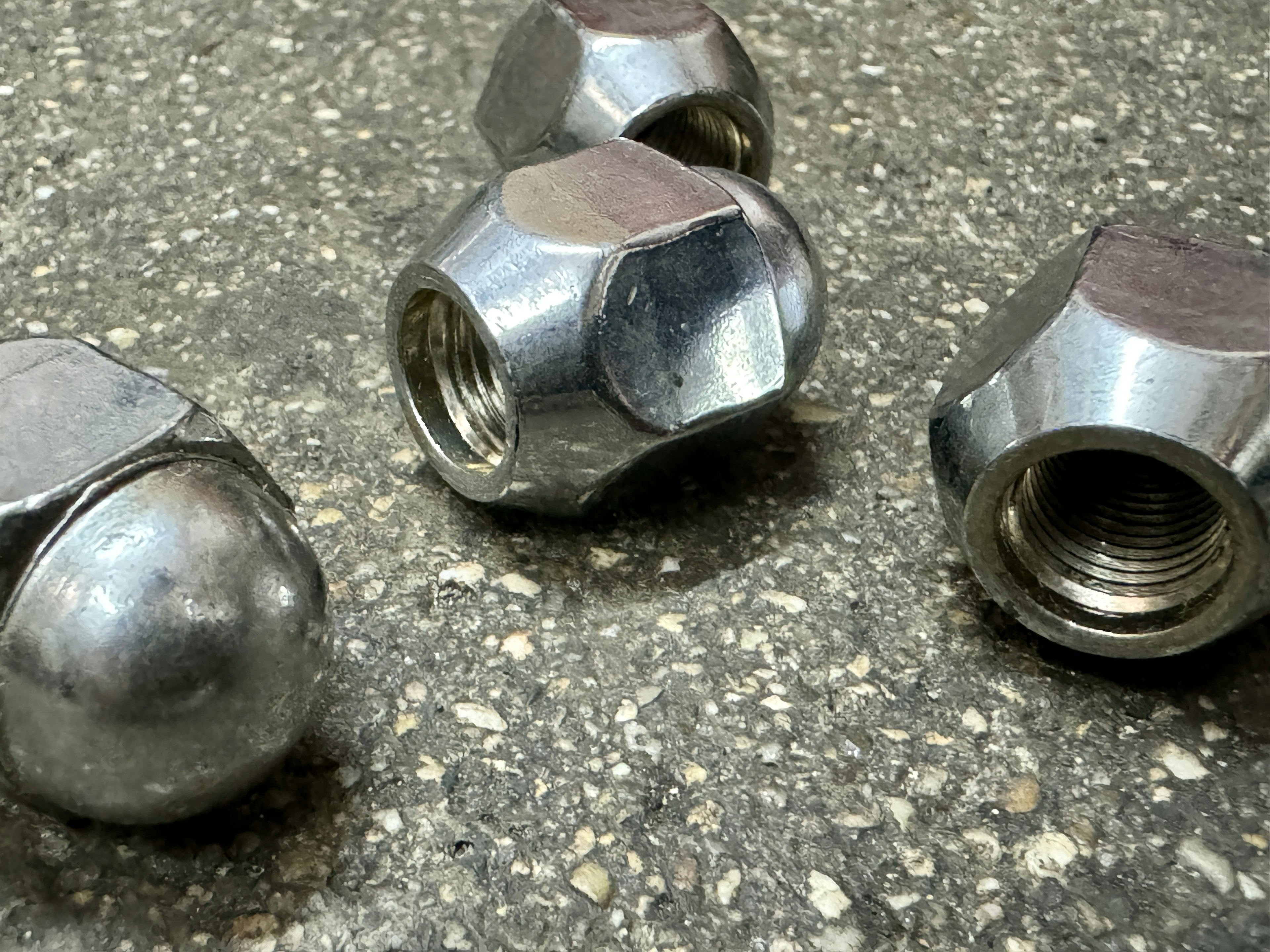 Metal nuts placed on a concrete surface