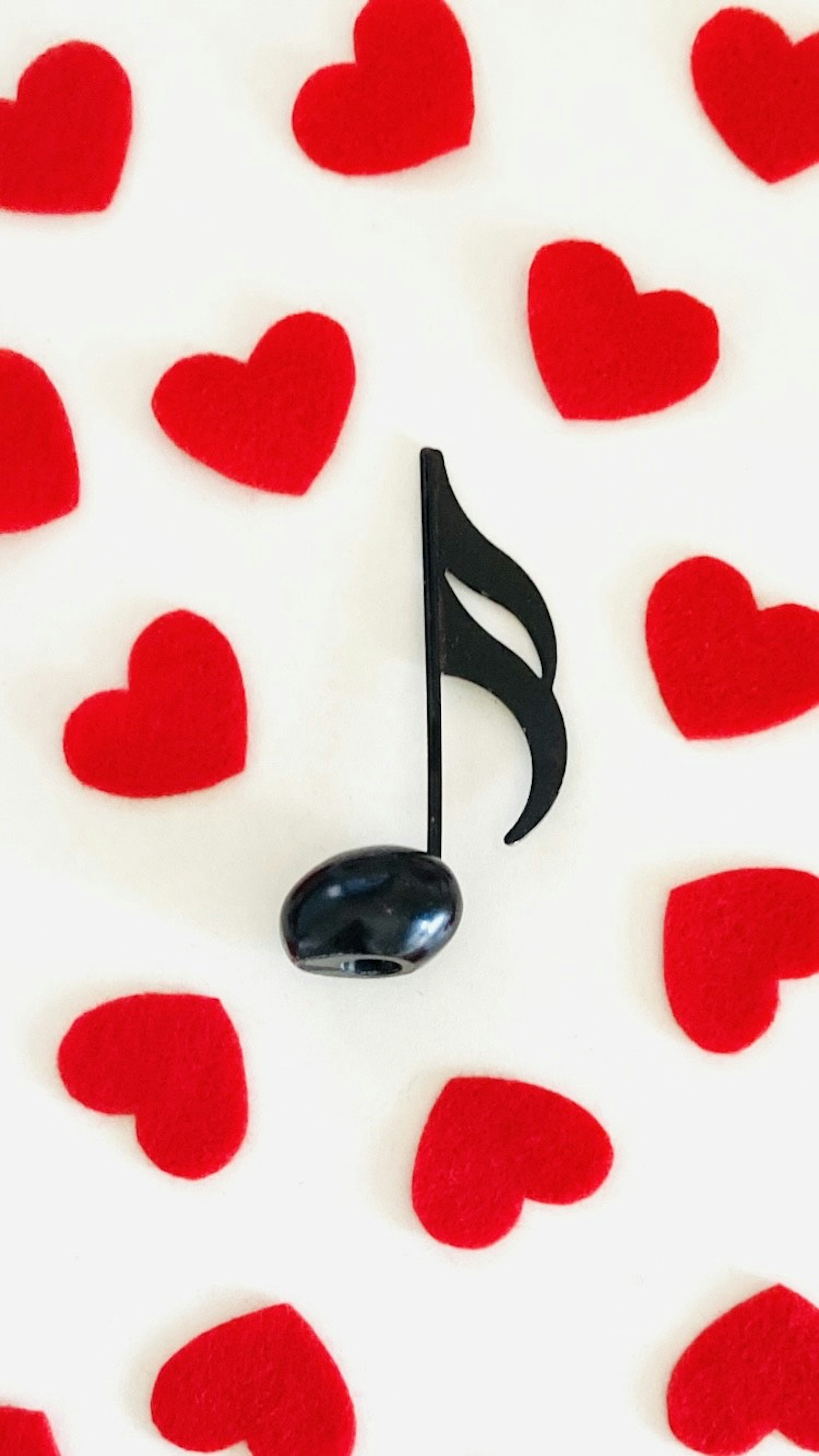 Image of a black musical note surrounded by red hearts