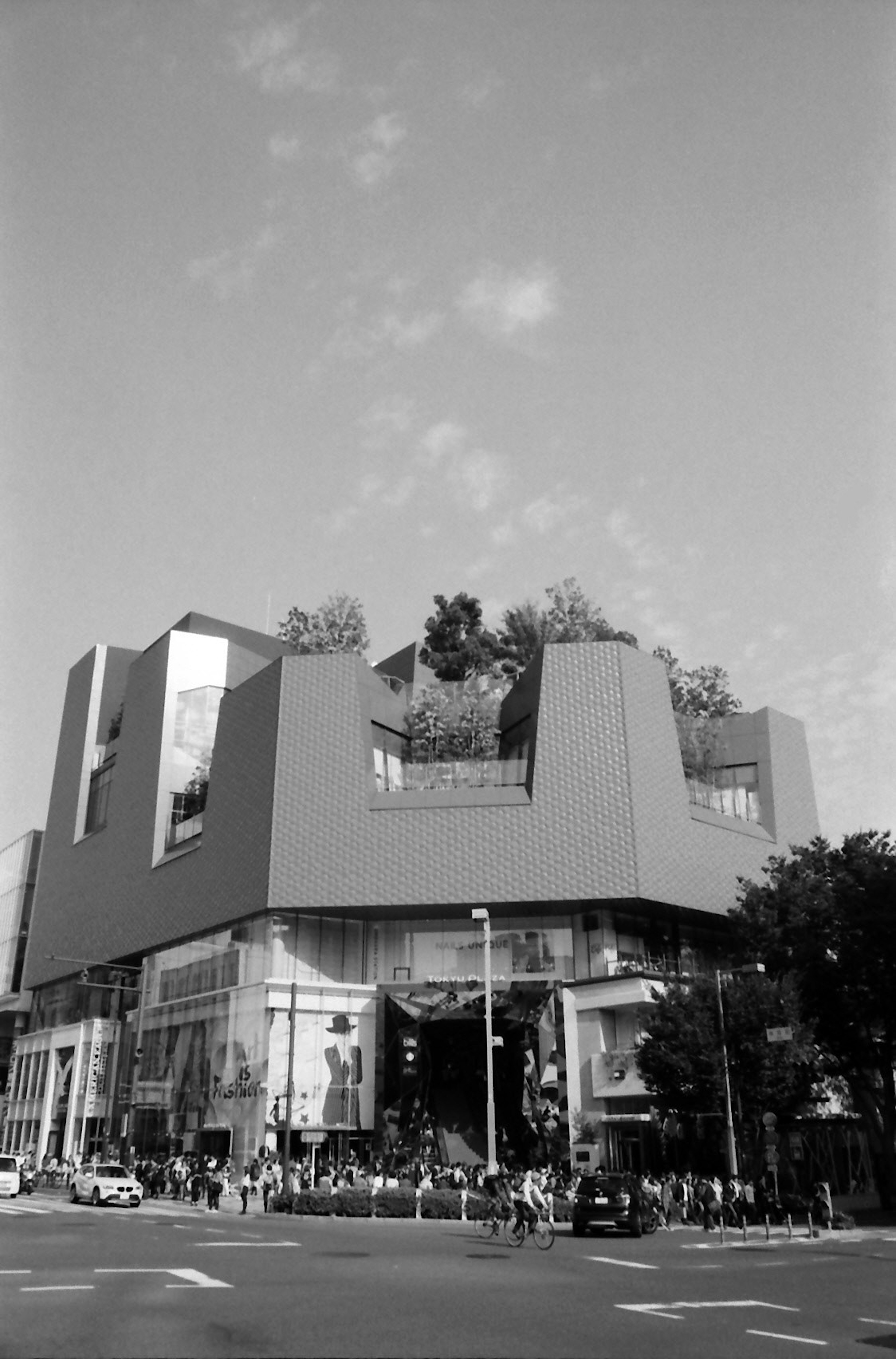 Exterior de un edificio moderno con vegetación en la azotea en un entorno urbano