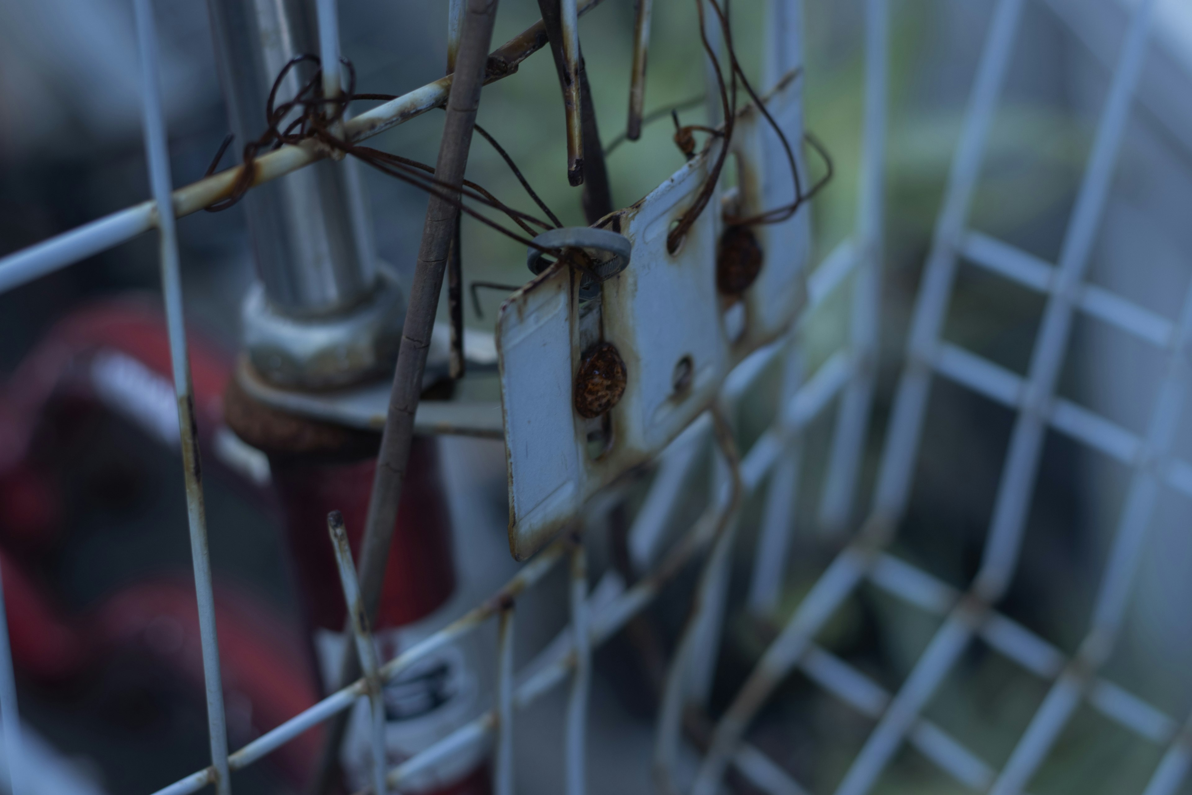 Rusty metal plates hanging on a wire fence