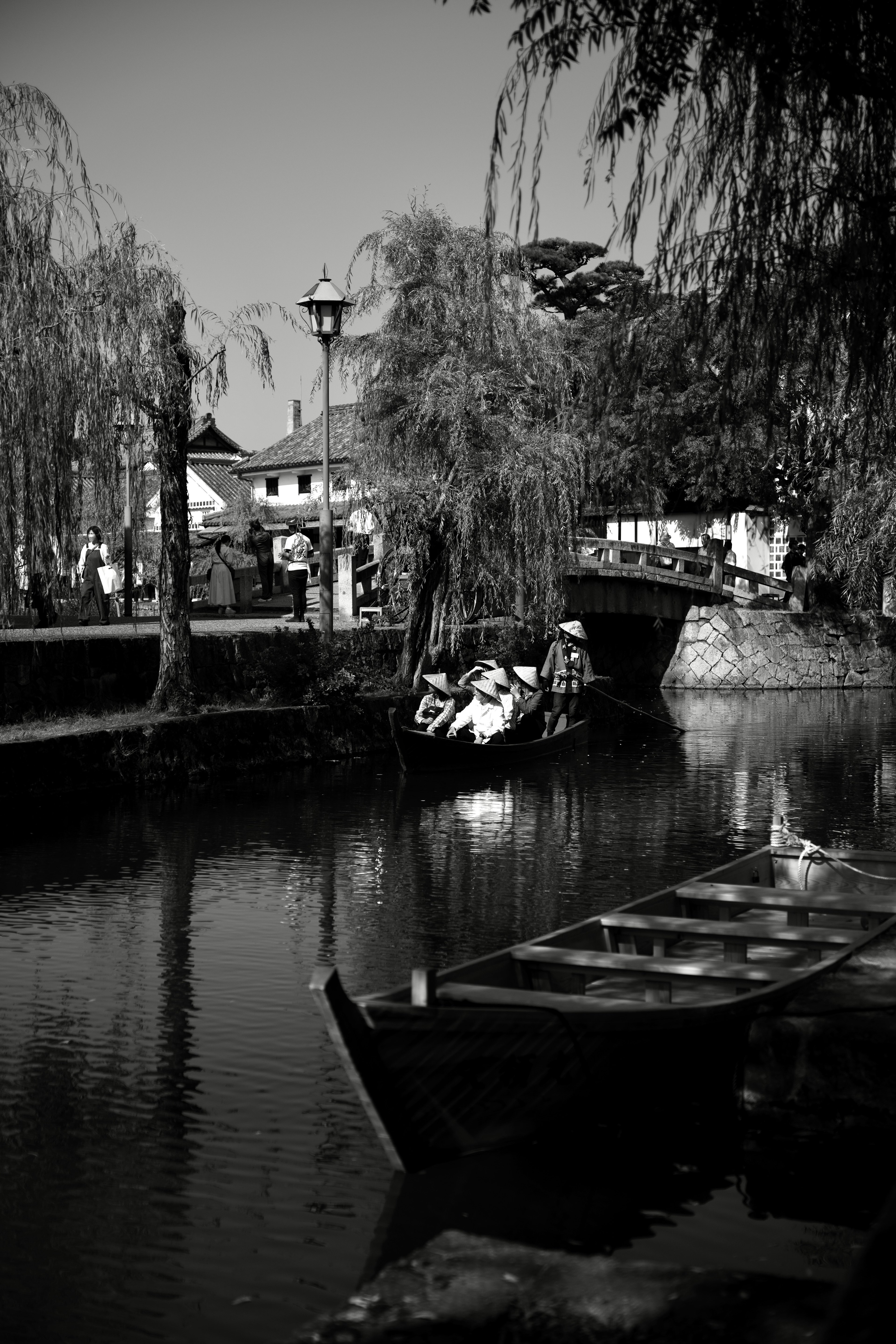 Scène de canal sereine avec un bateau et des saules