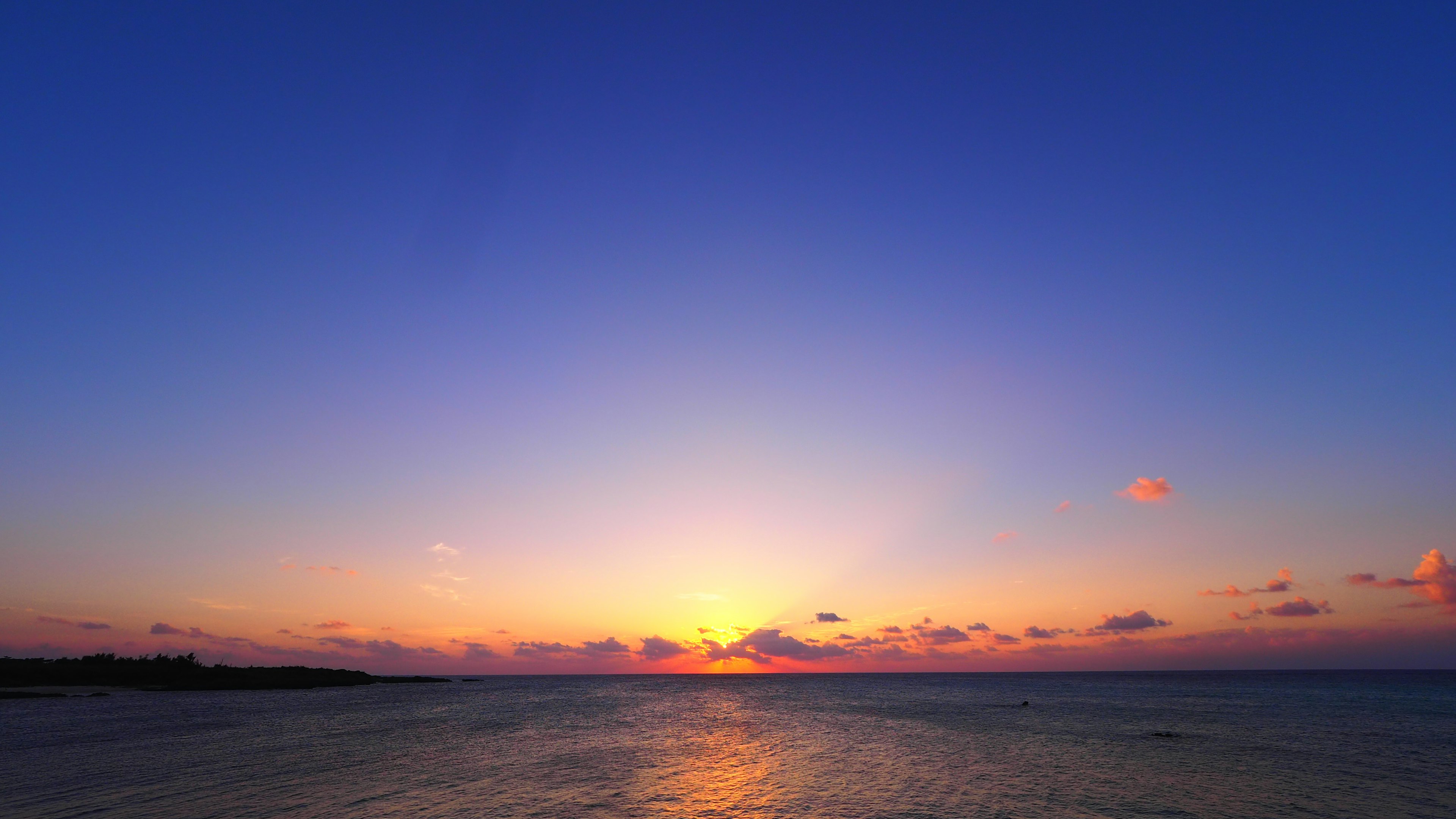 Beautiful sunset over the ocean with blue sky and orange hues