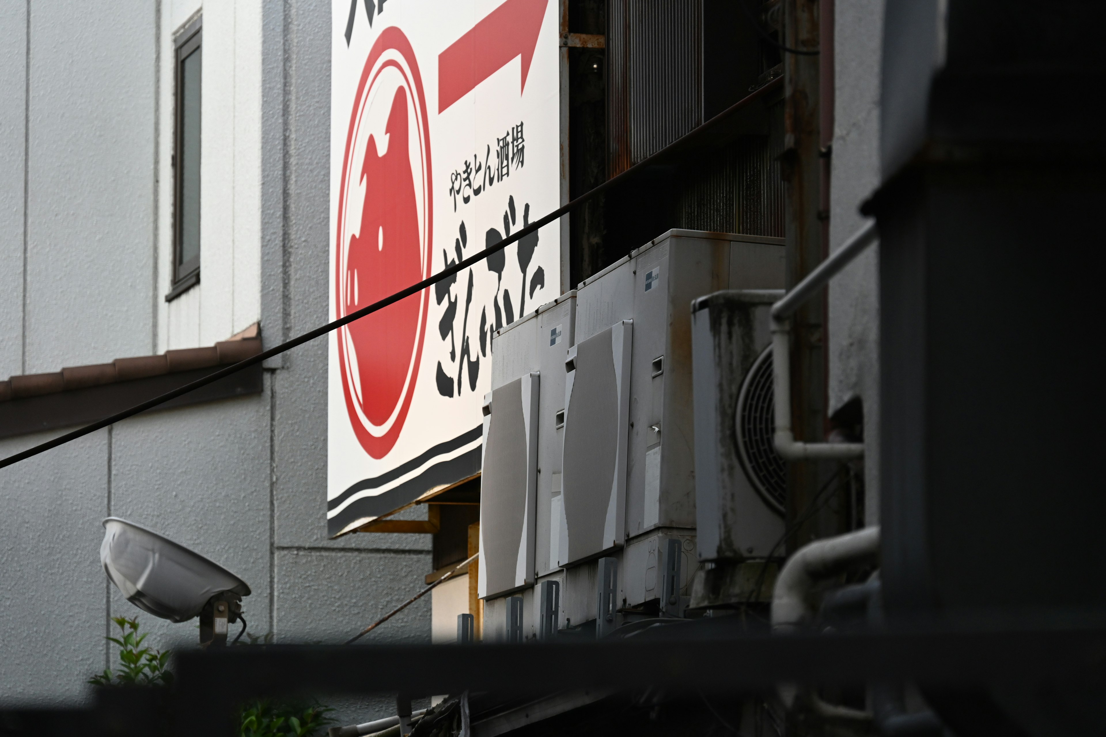 Red sign with white text of a Japanese restaurant exterior