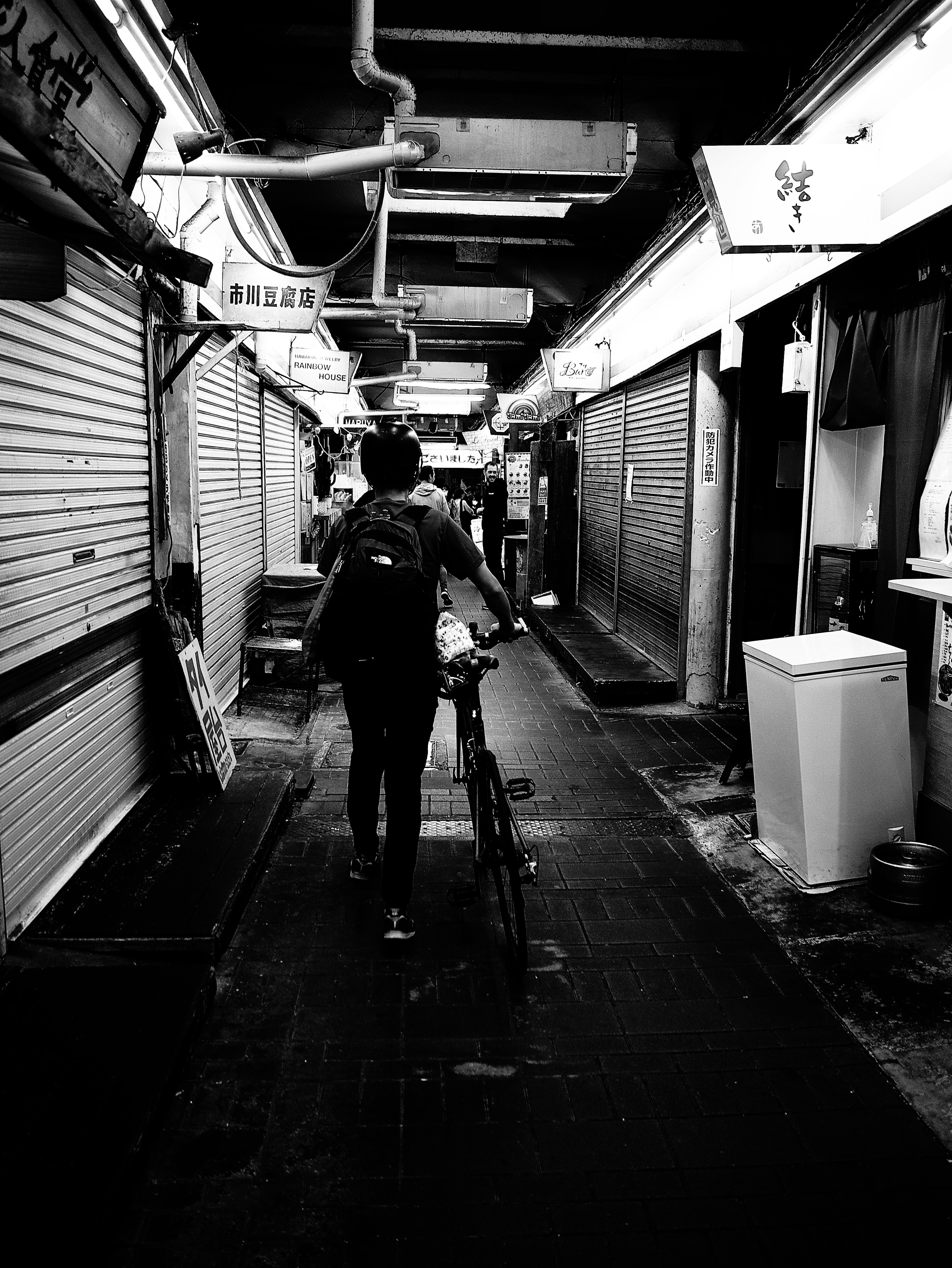 Una persona montando una bicicleta en un callejón poco iluminado