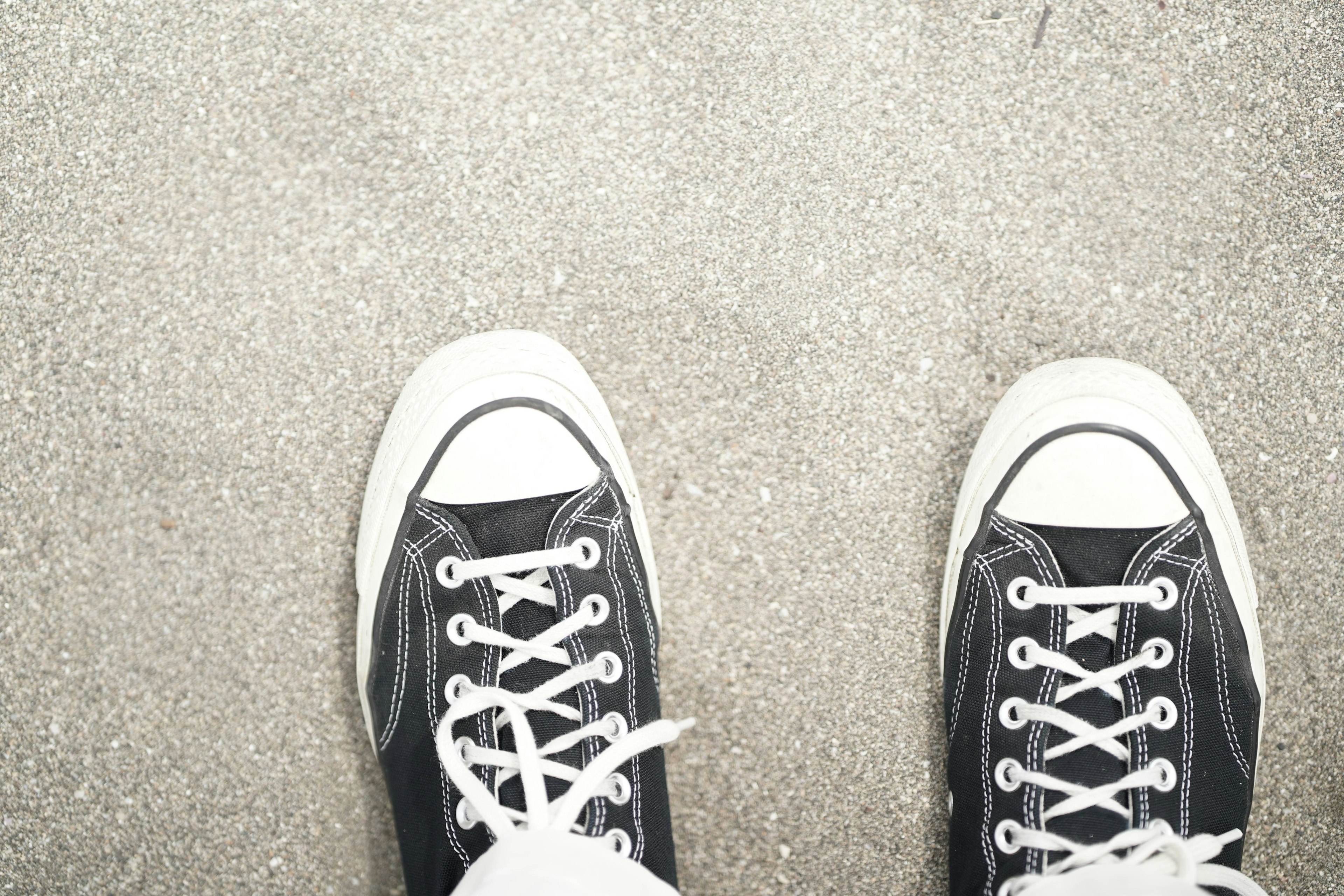 Black and white sneakers placed on gray ground