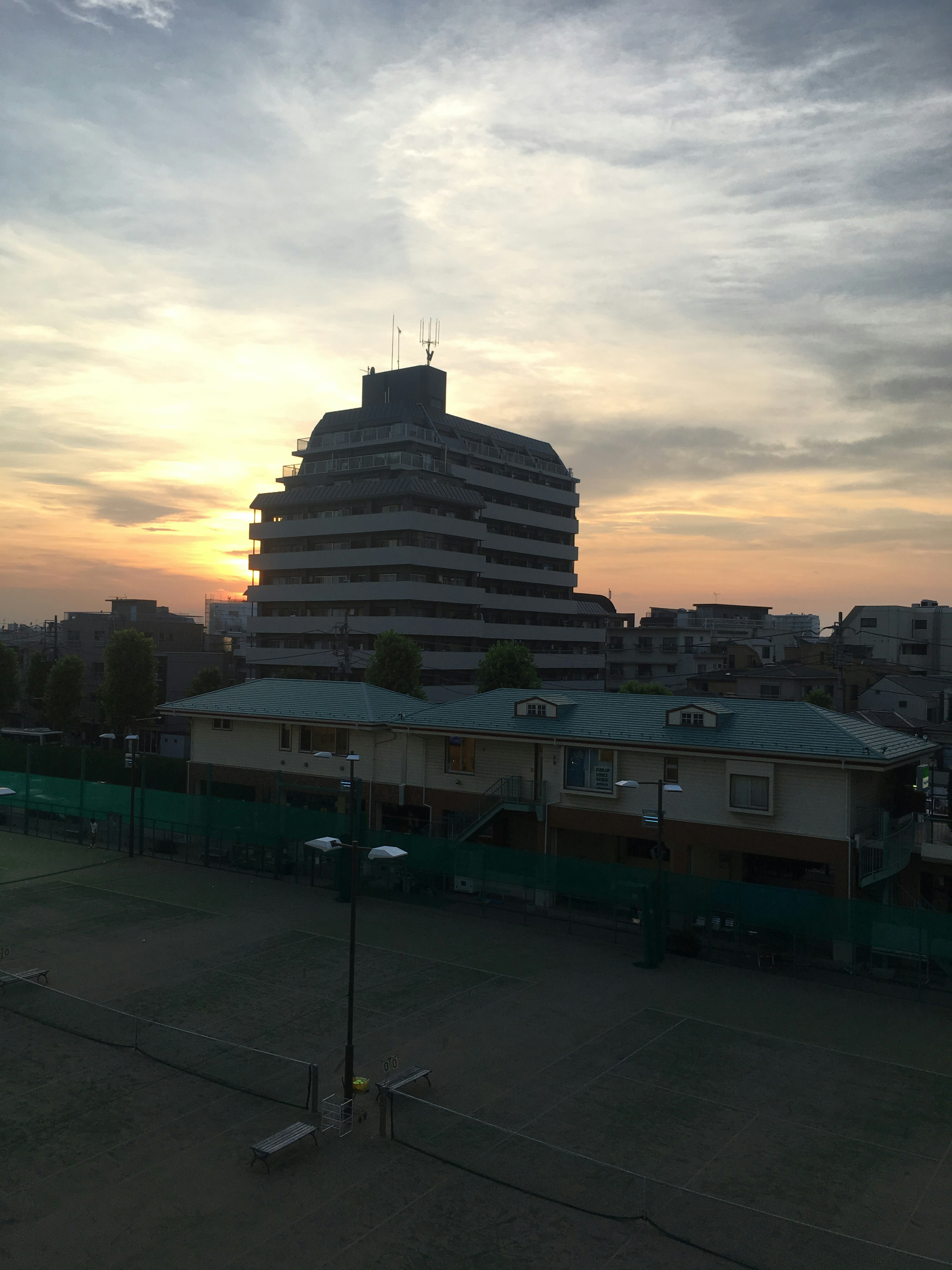 夕日を背景にした建物のシルエットと静かな風景