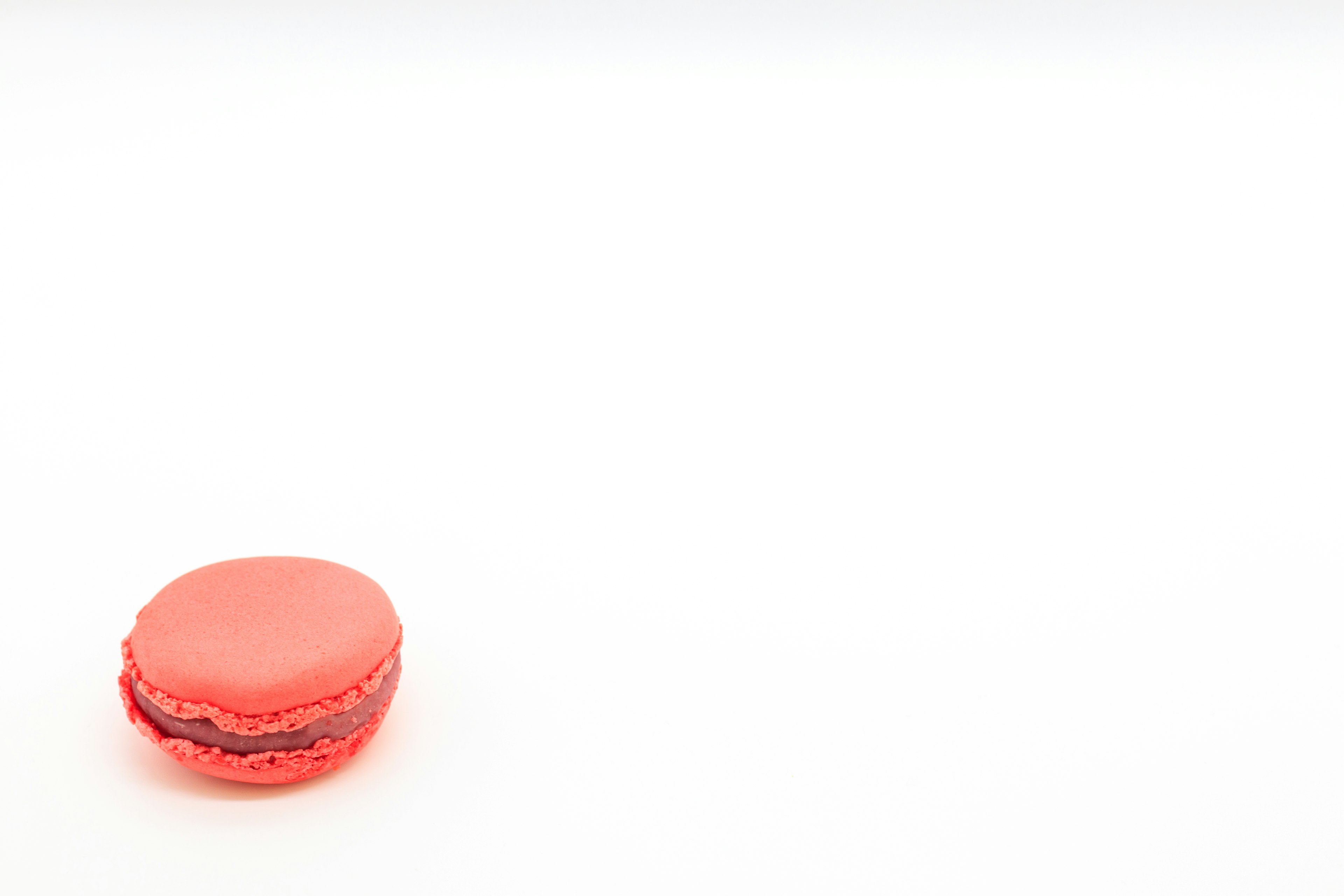 A red macaron placed on a white background