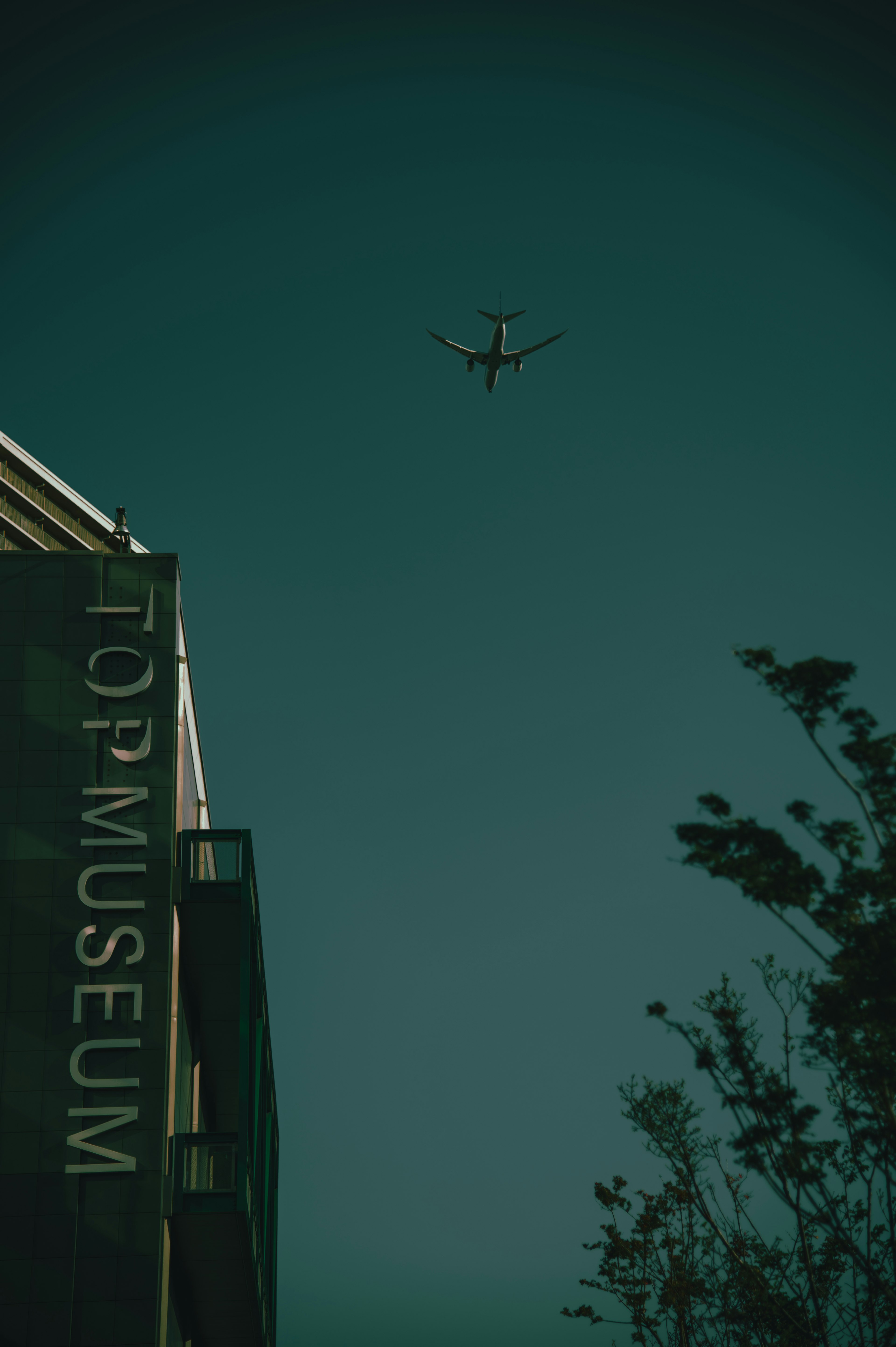 Imagen de un avión volando sobre un edificio de museo