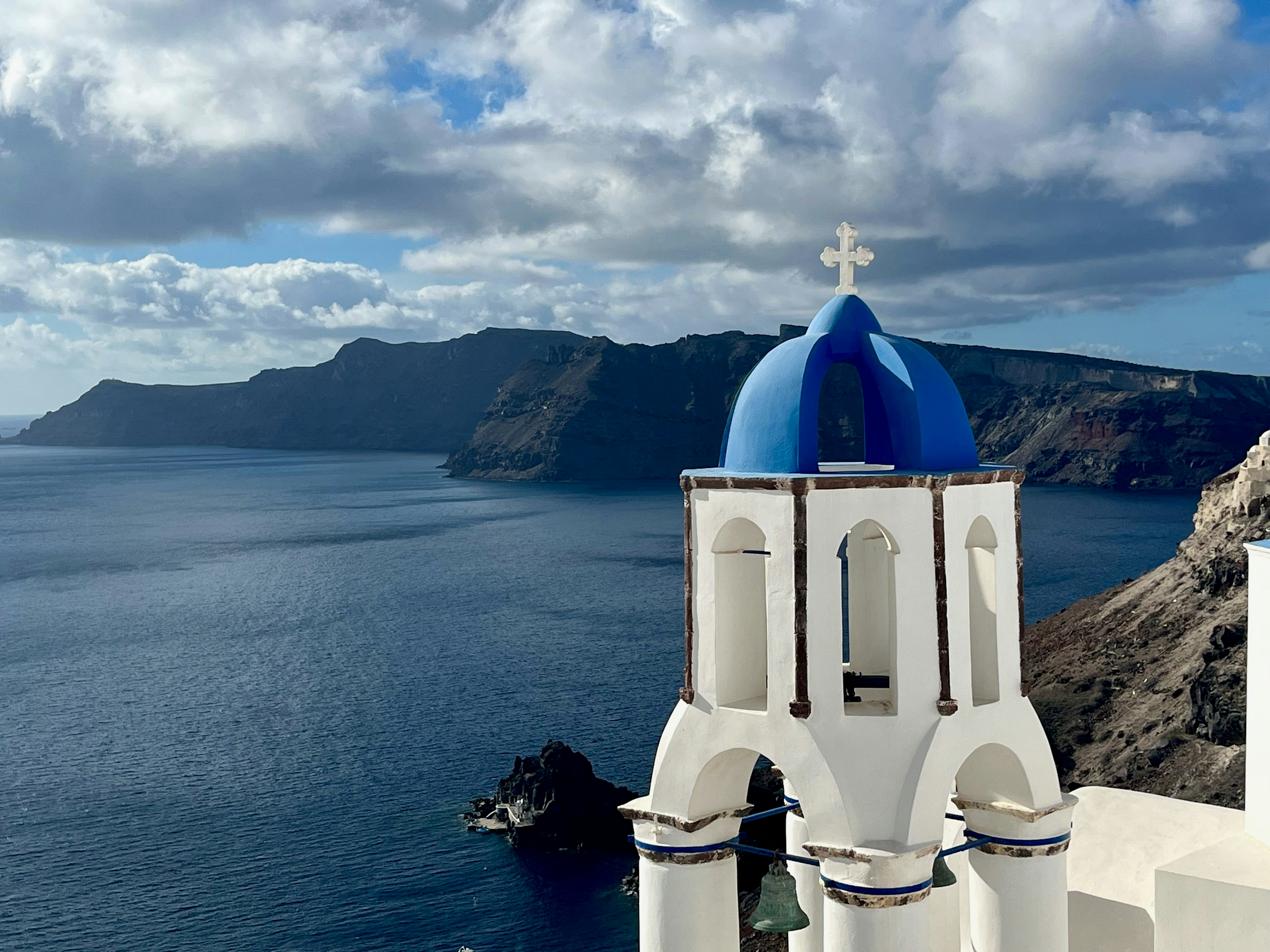 Una vista panoramica del mare Egeo con una torre di chiesa a cupola blu