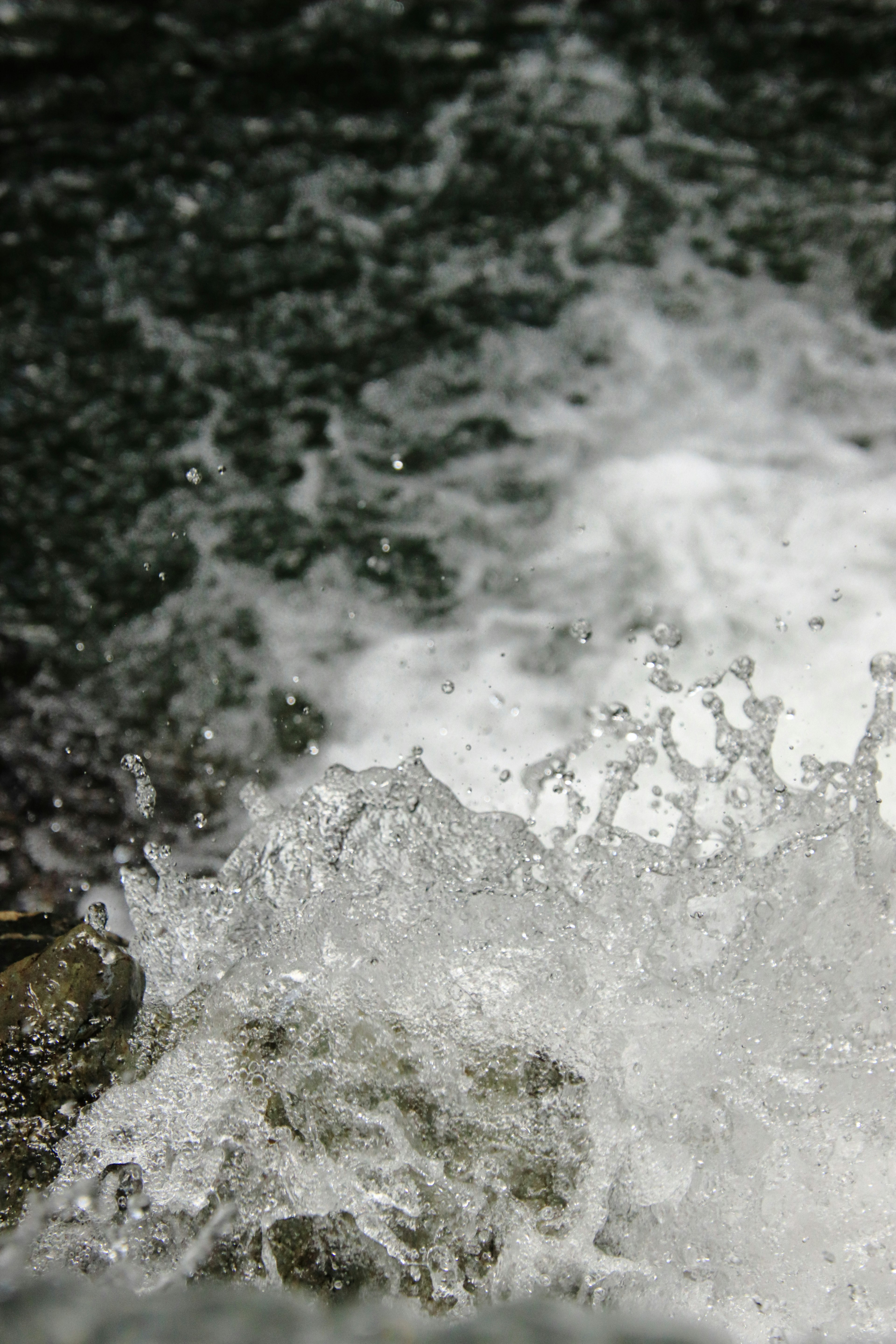 Onde d'acqua che si infrangono contro le rocce creando schiuma bianca