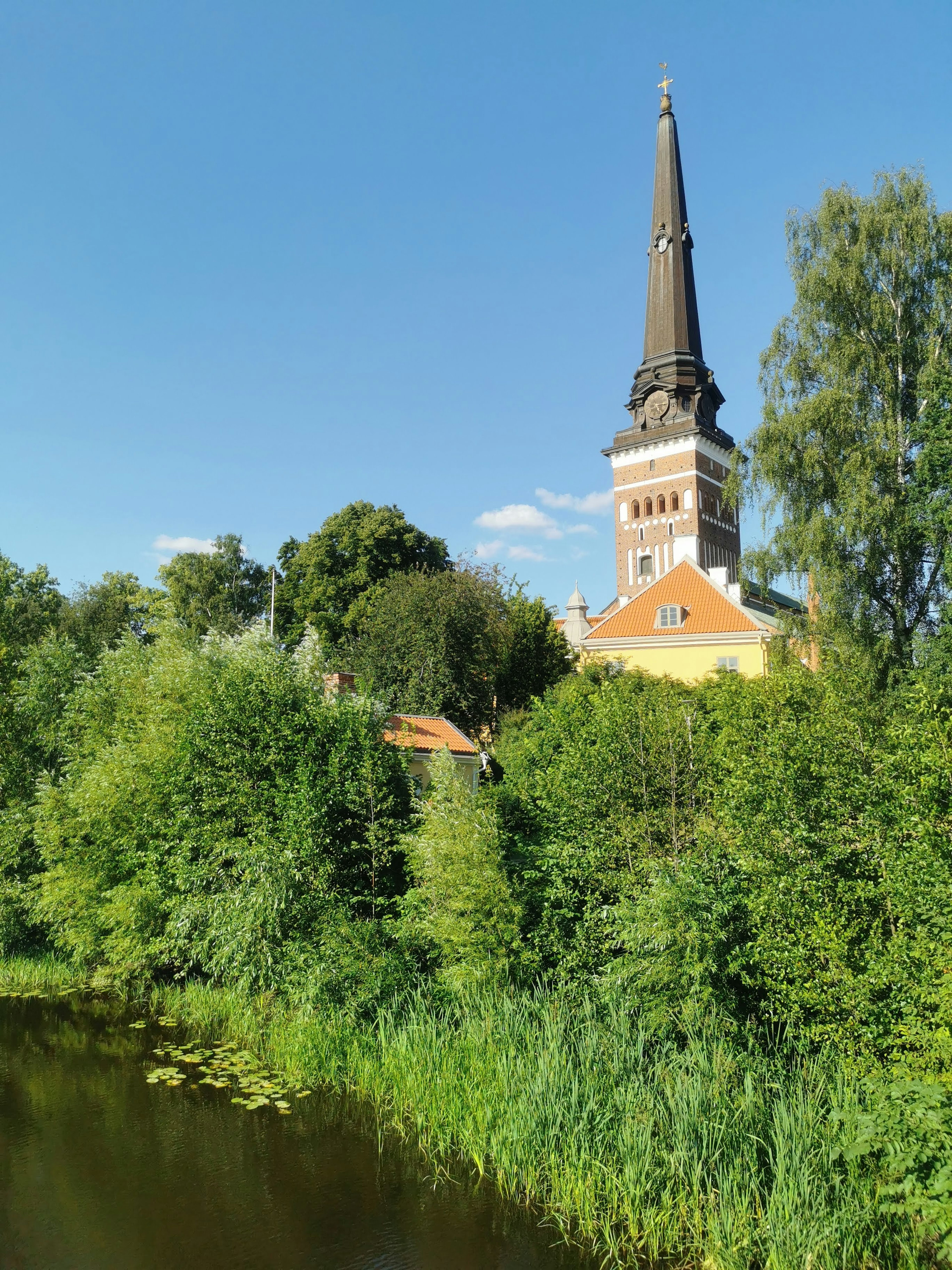 Scenic view of a building with a tall spire surrounded by lush greenery