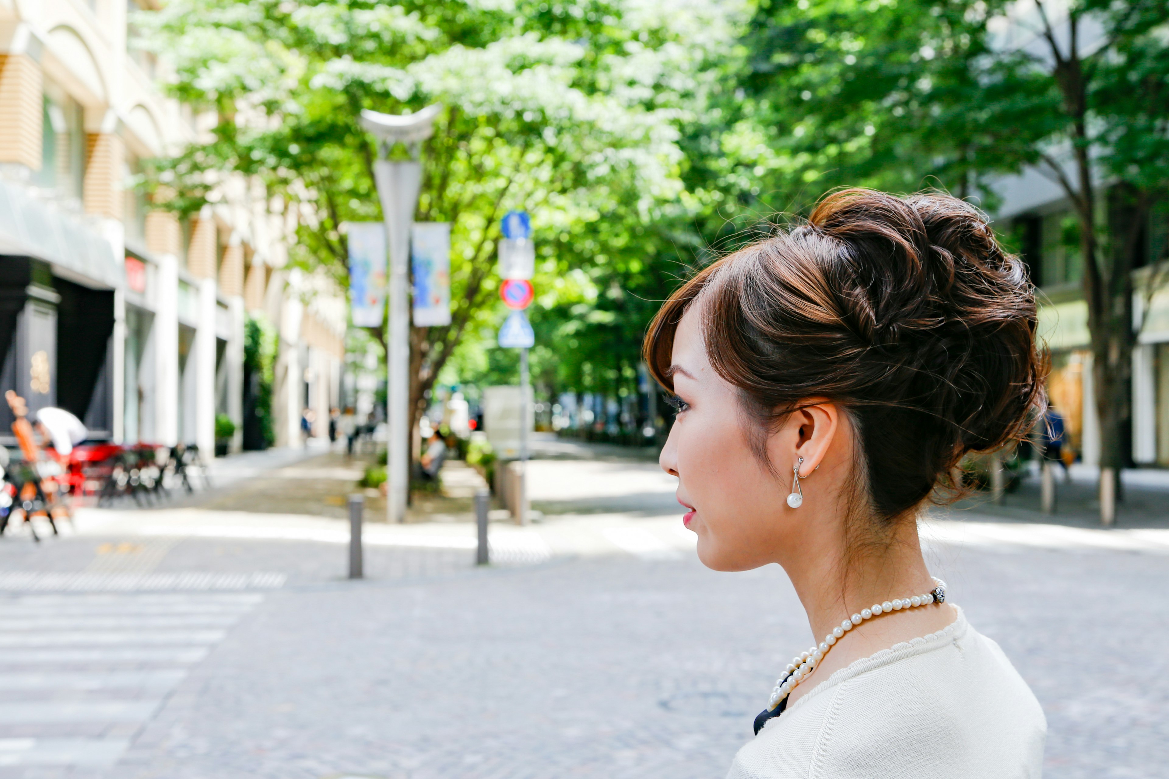 Woman with elegant hairstyle standing on a vibrant street