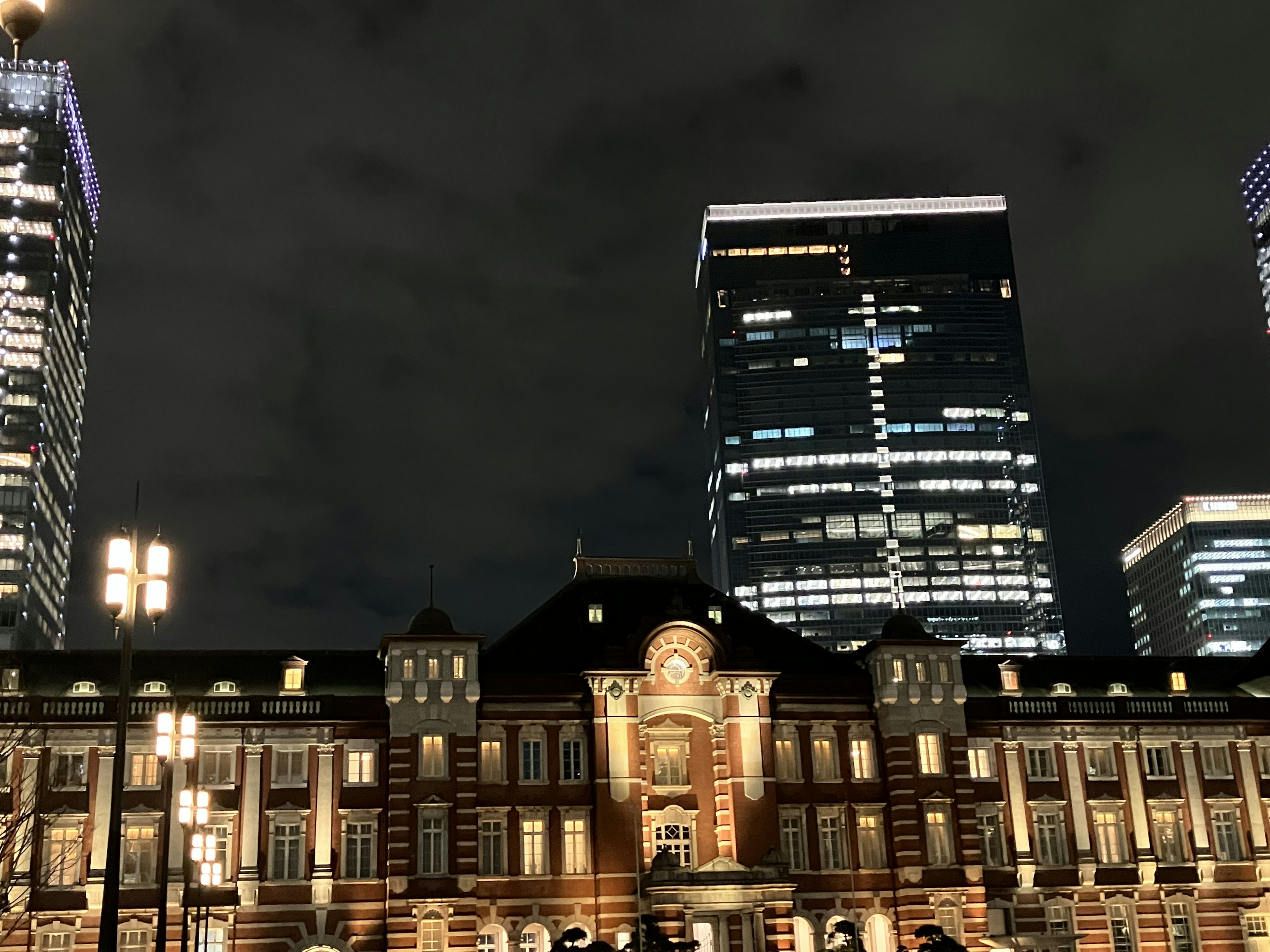 東京駅の夜景と近代的な高層ビルのコントラスト