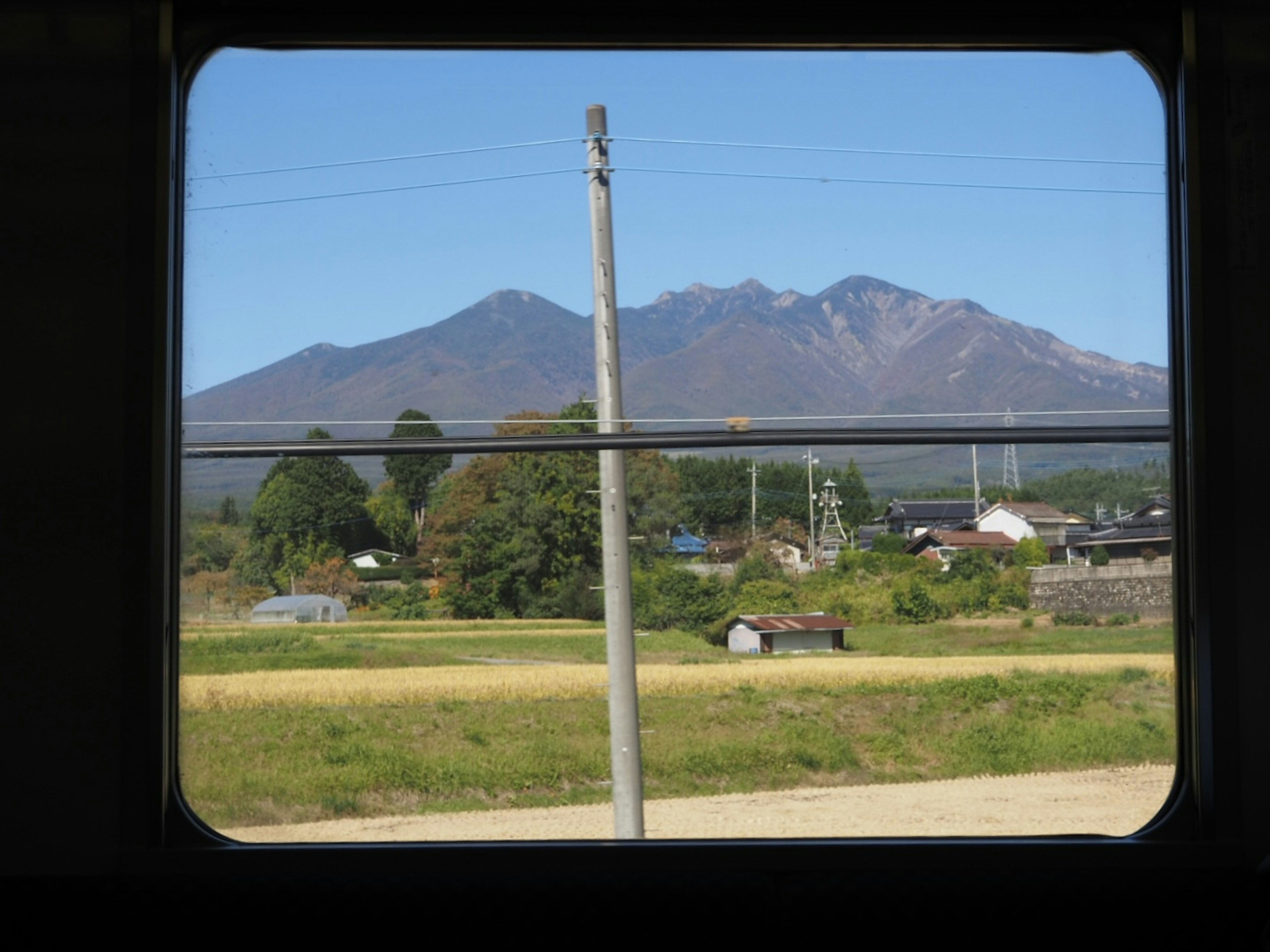 車窓から見える山と田園風景