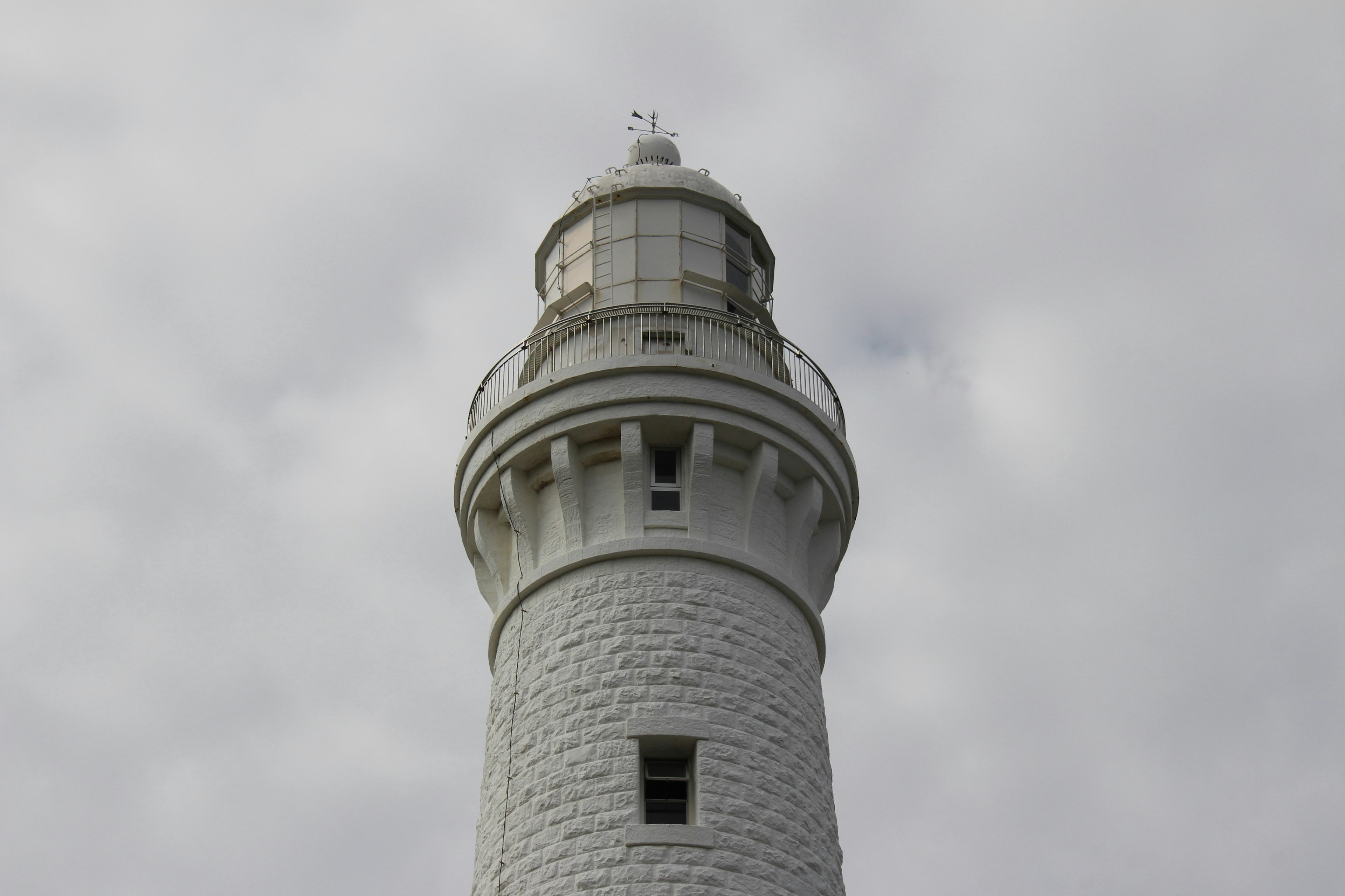 Vue du haut d'un phare blanc sous un ciel nuageux