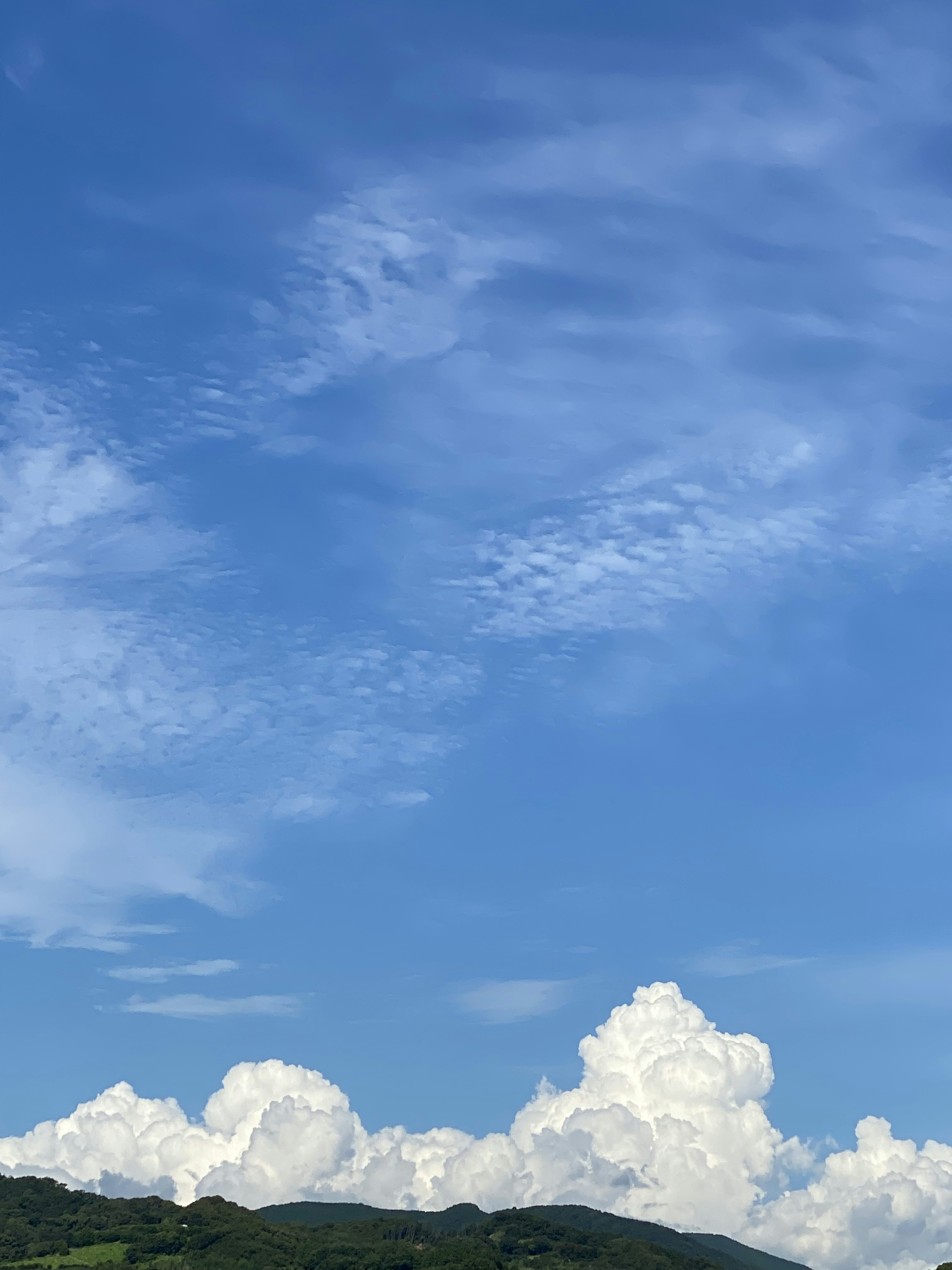 Un paisaje con nubes blancas flotando en un cielo azul