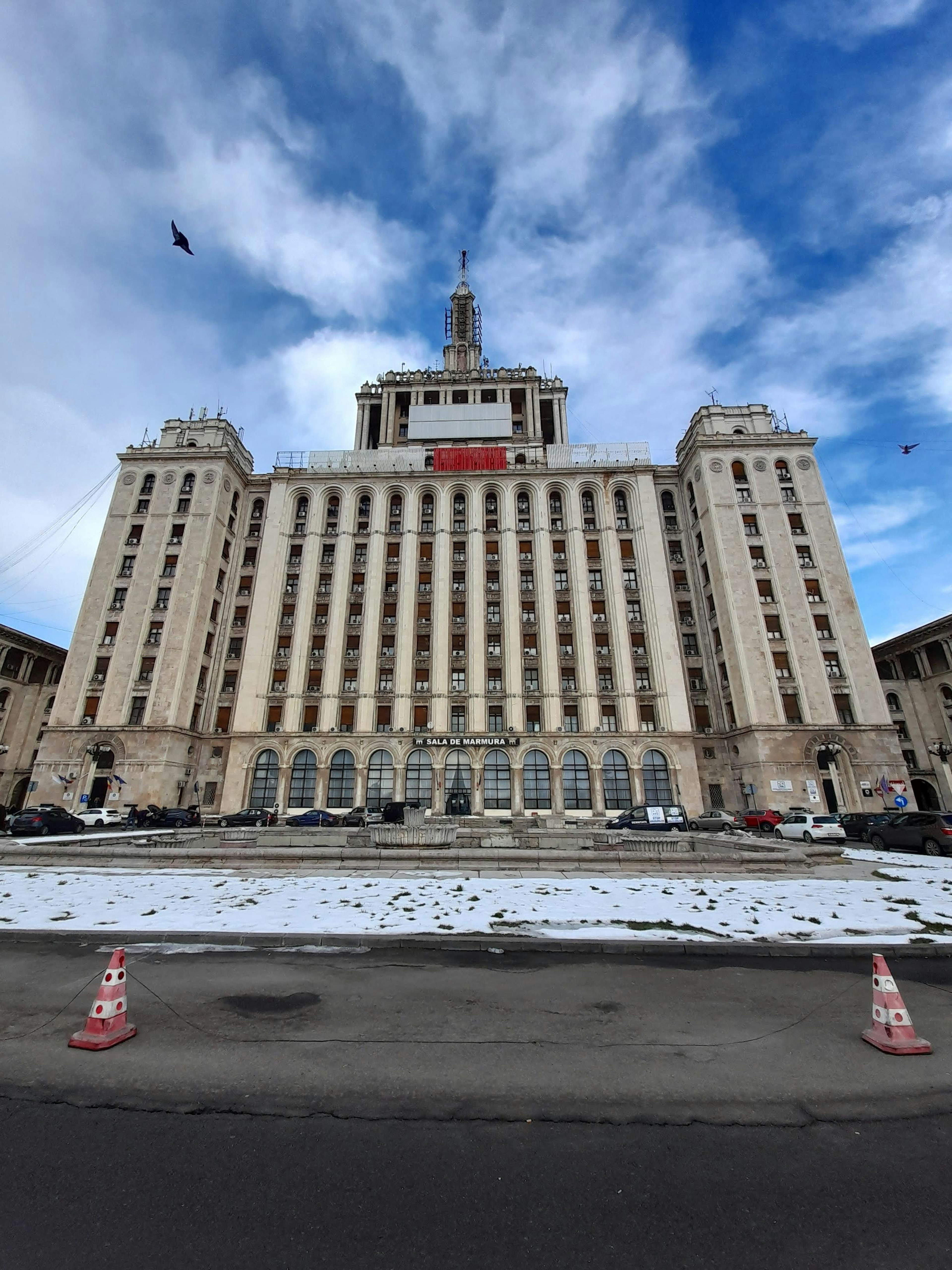 Grand bâtiment avec de la neige au premier plan et un ciel bleu