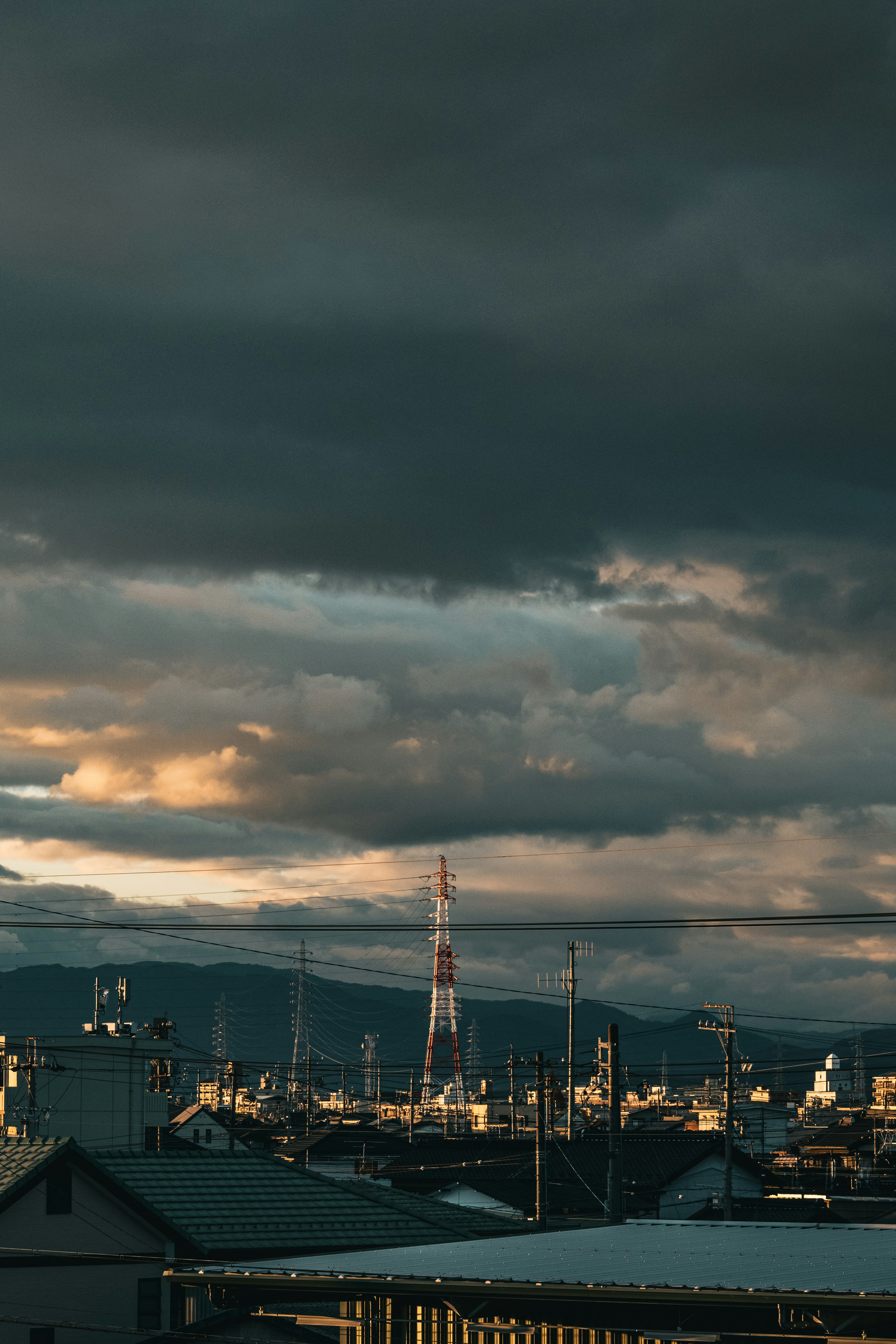 Cityscape under dark clouds with a tall tower