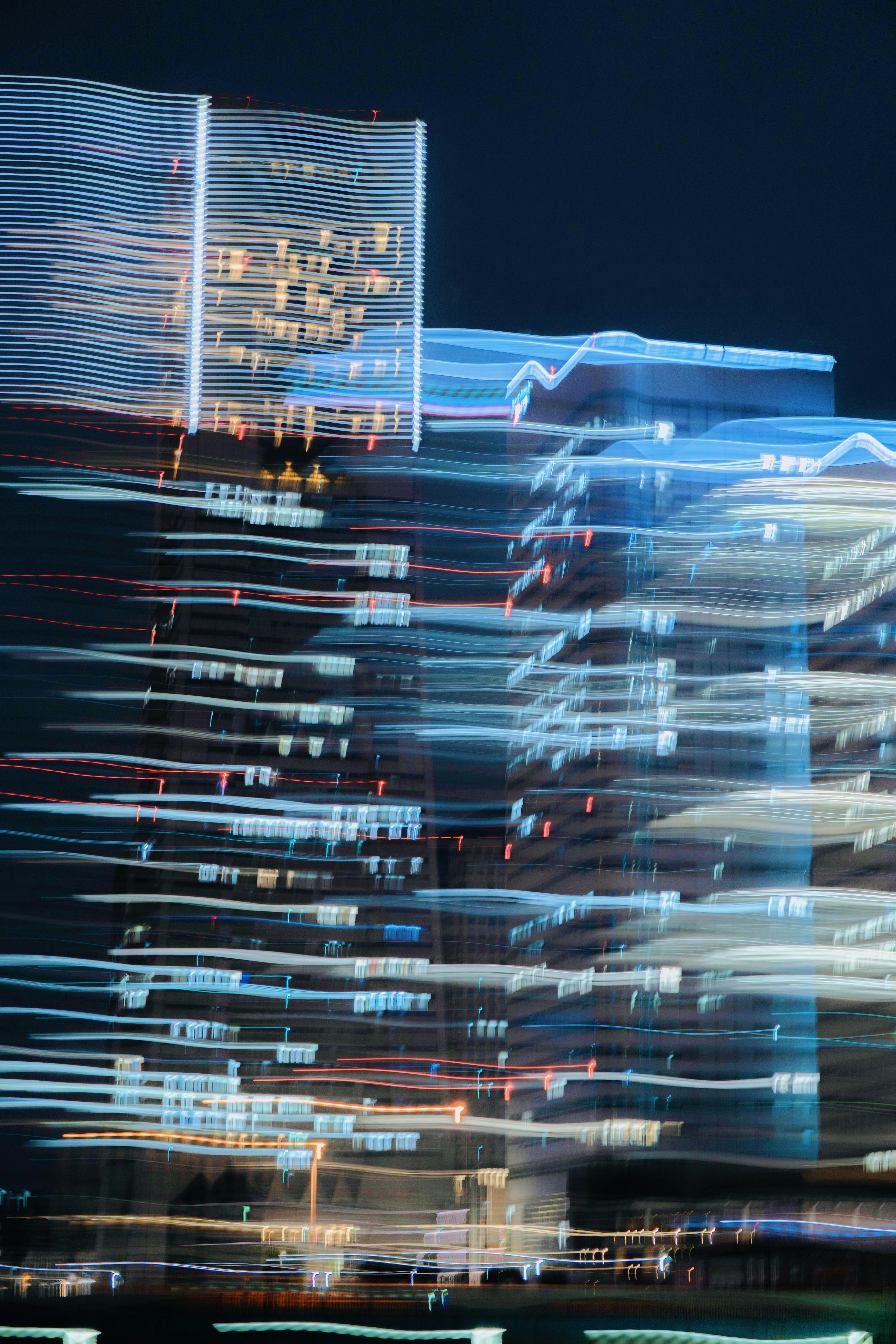 Blurred city buildings with light trails at night