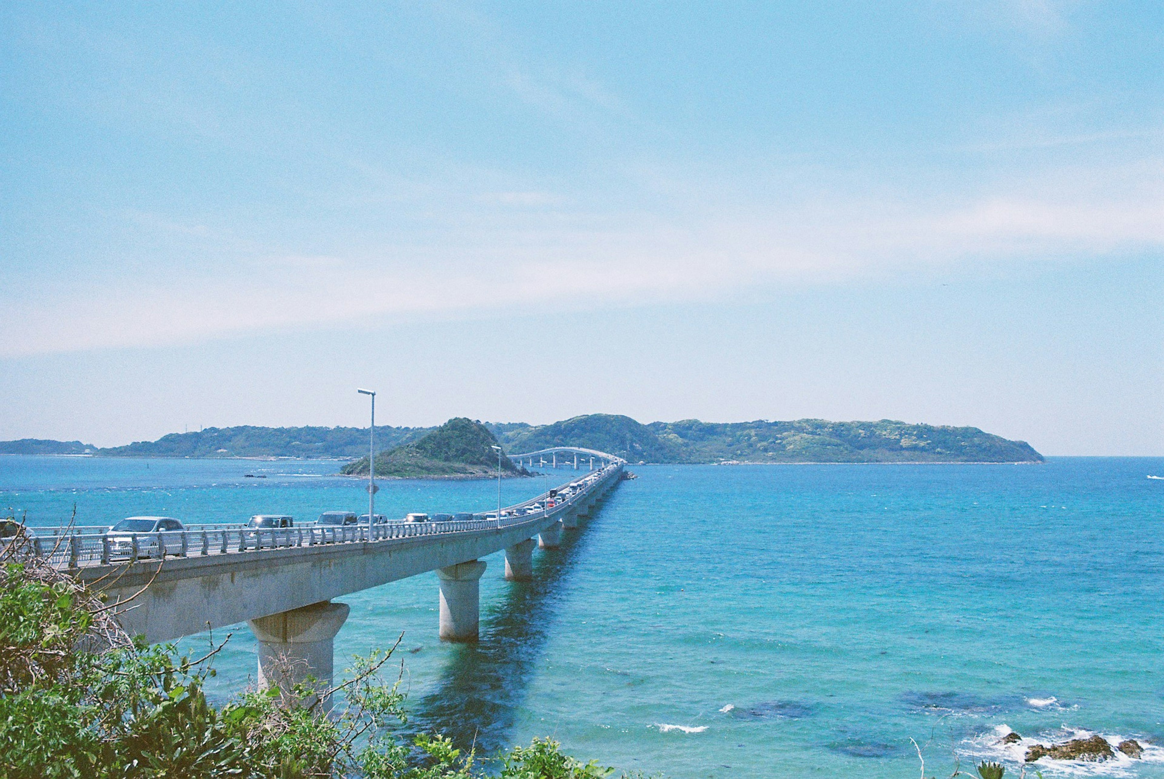 Pemandangan jembatan panjang di atas air biru dan langit