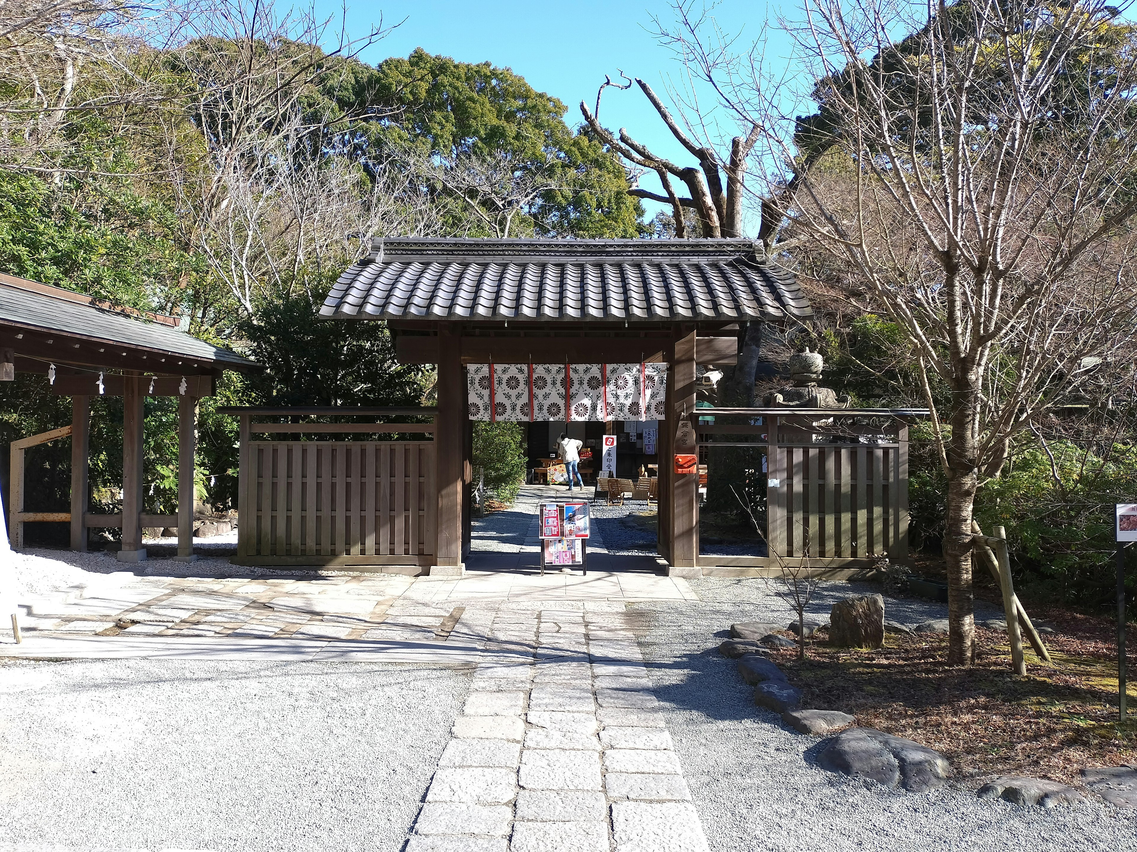 Eingang eines traditionellen japanischen Tempels mit Holztor und Steinweg