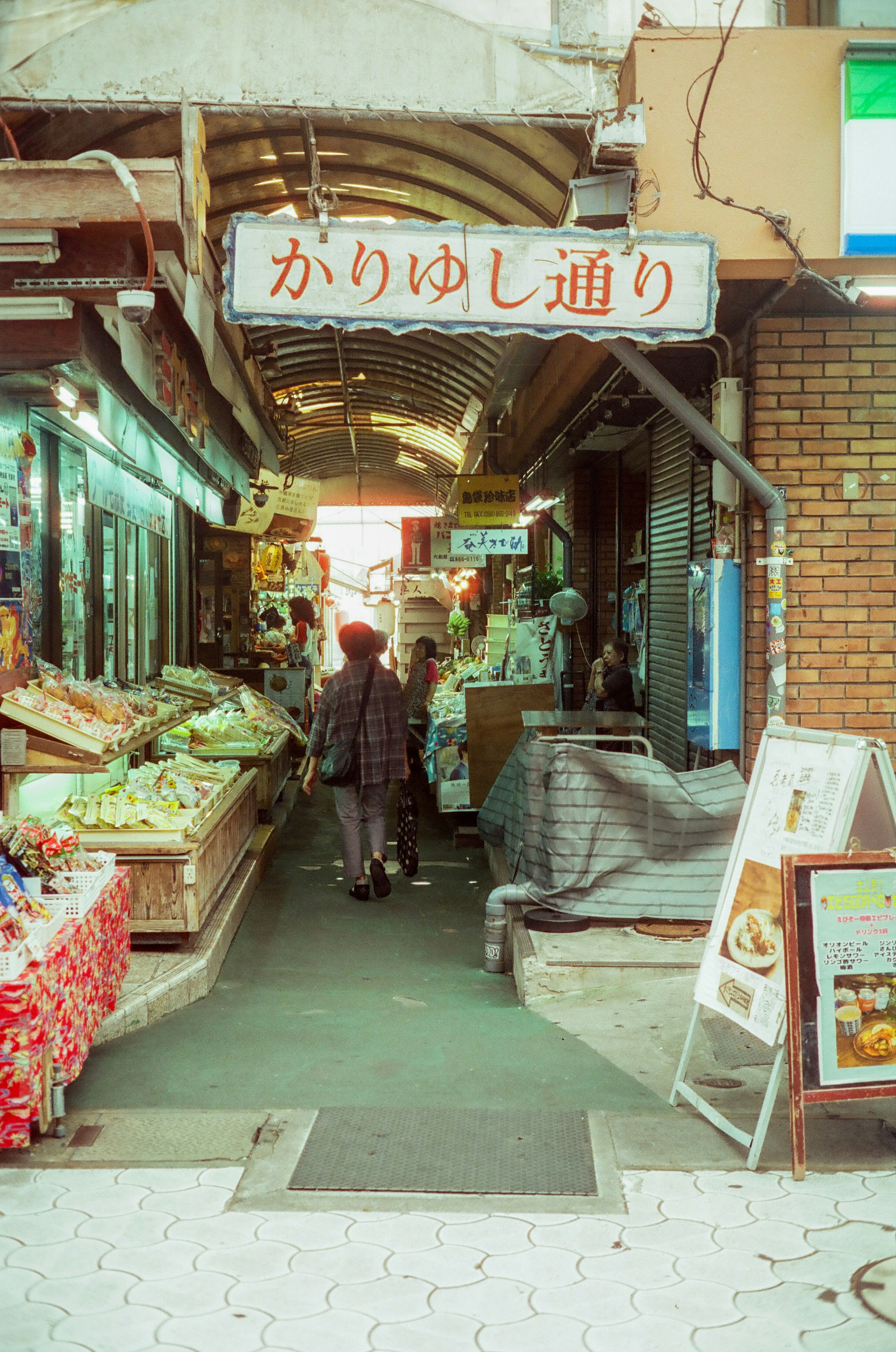 市場の通りに並ぶ新鮮な野菜と果物の店と人々