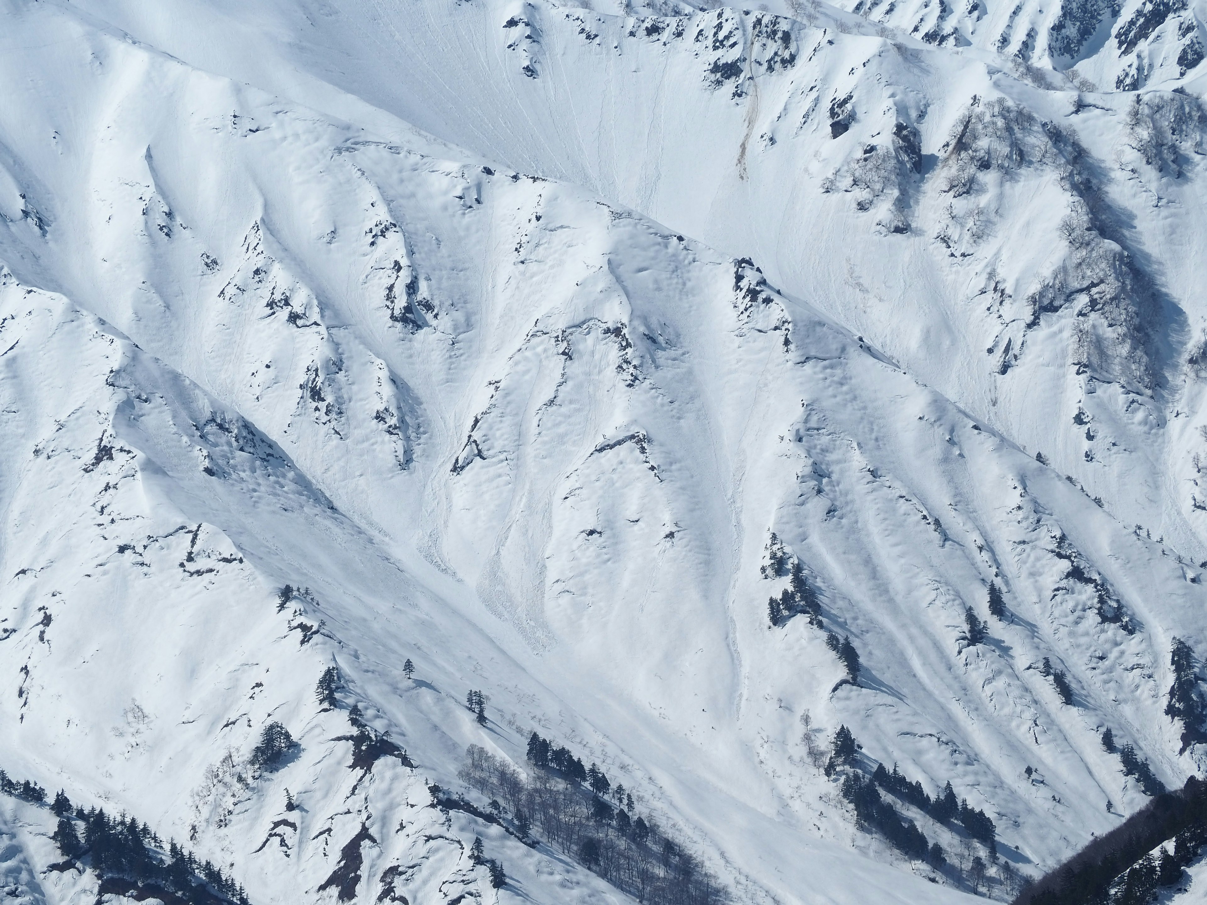 Luftaufnahme von schneebedeckten Bergabhängen