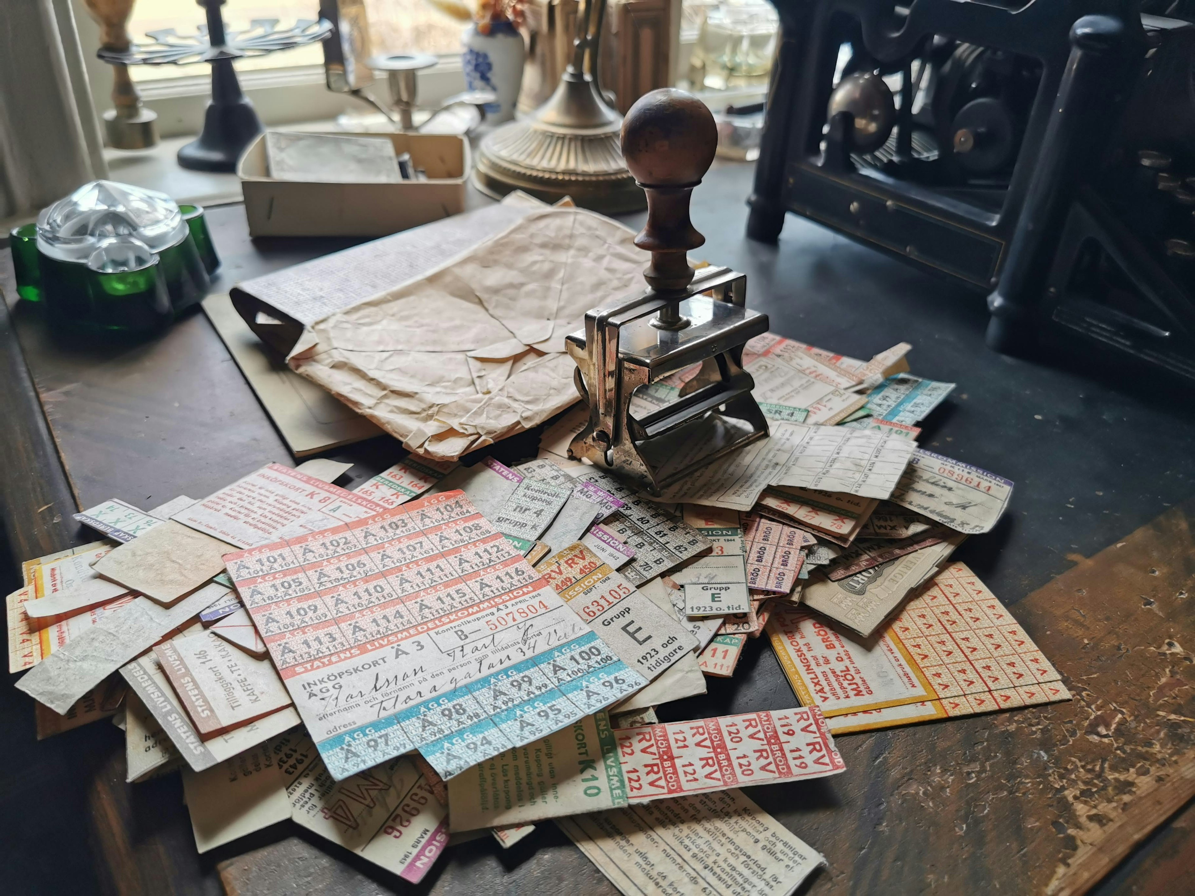 A collection of old paper scraps and a stamp on a wooden table