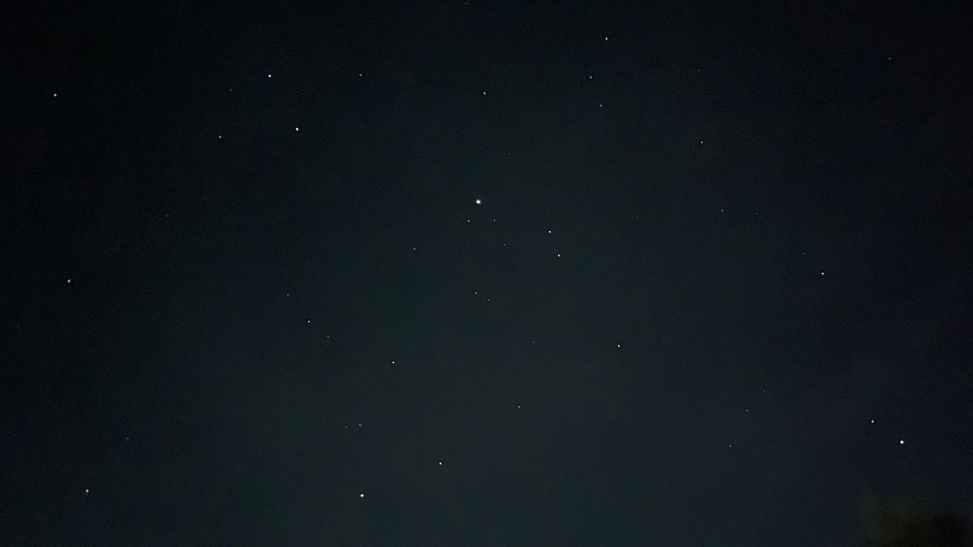 Foto del cielo nocturno con numerosas estrellas brillando sobre un fondo oscuro