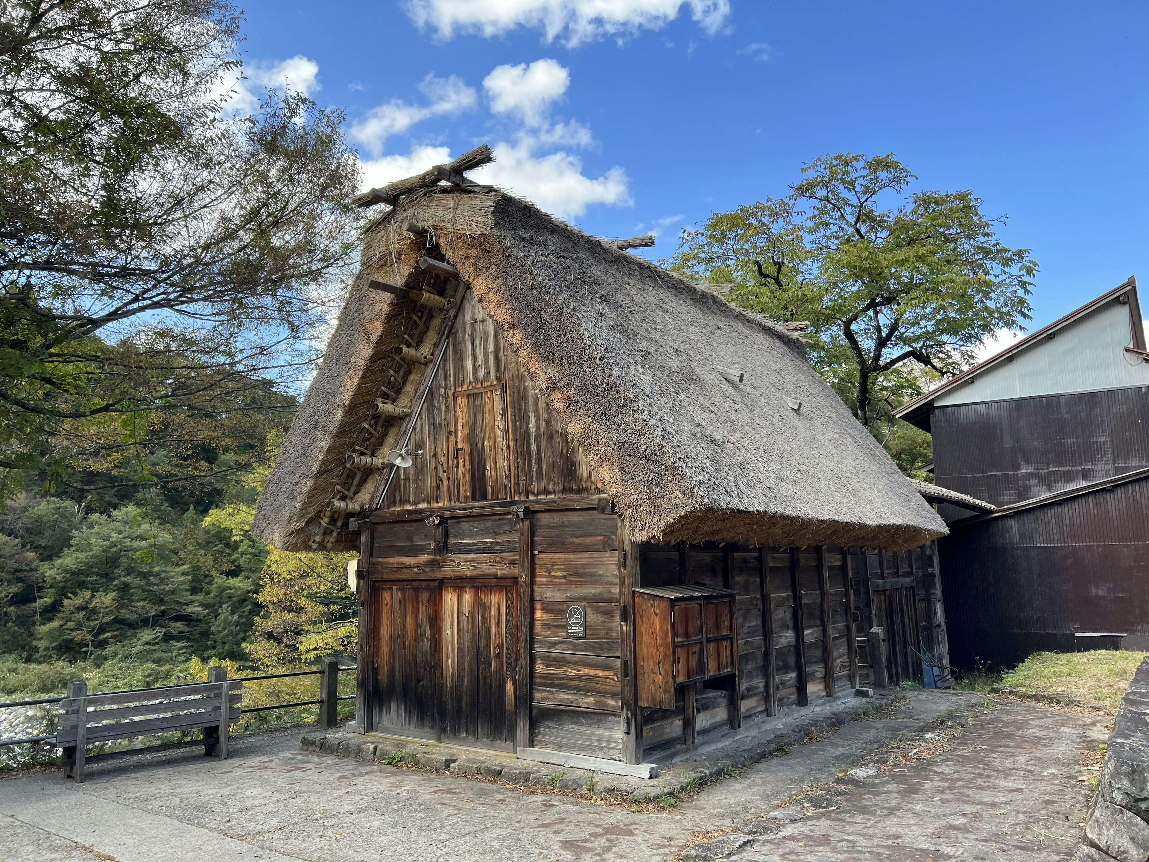 Esterno di una casa in legno con tetto di paglia tradizionale e natura circostante