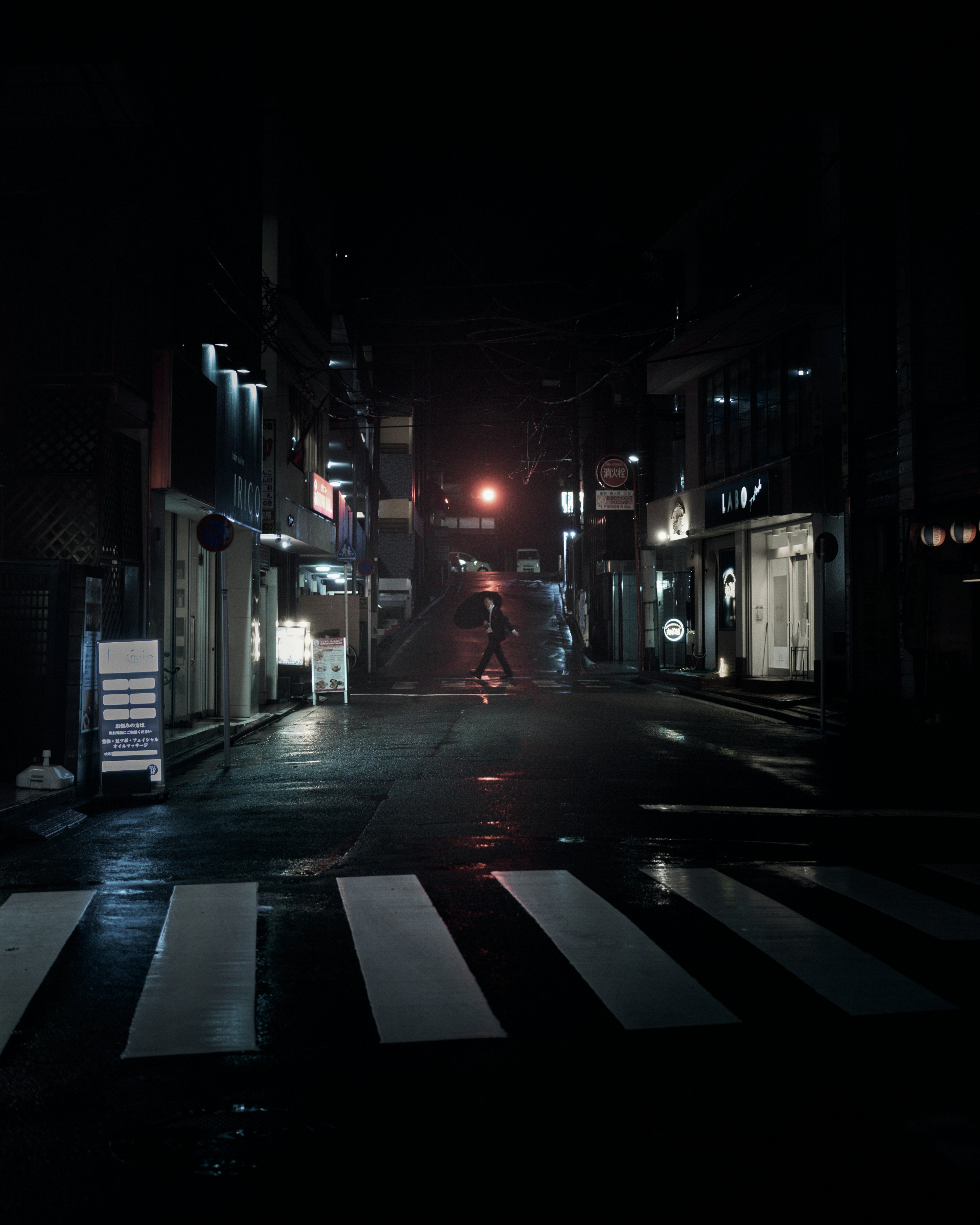 Quiet street corner at night with reflections and dim lighting