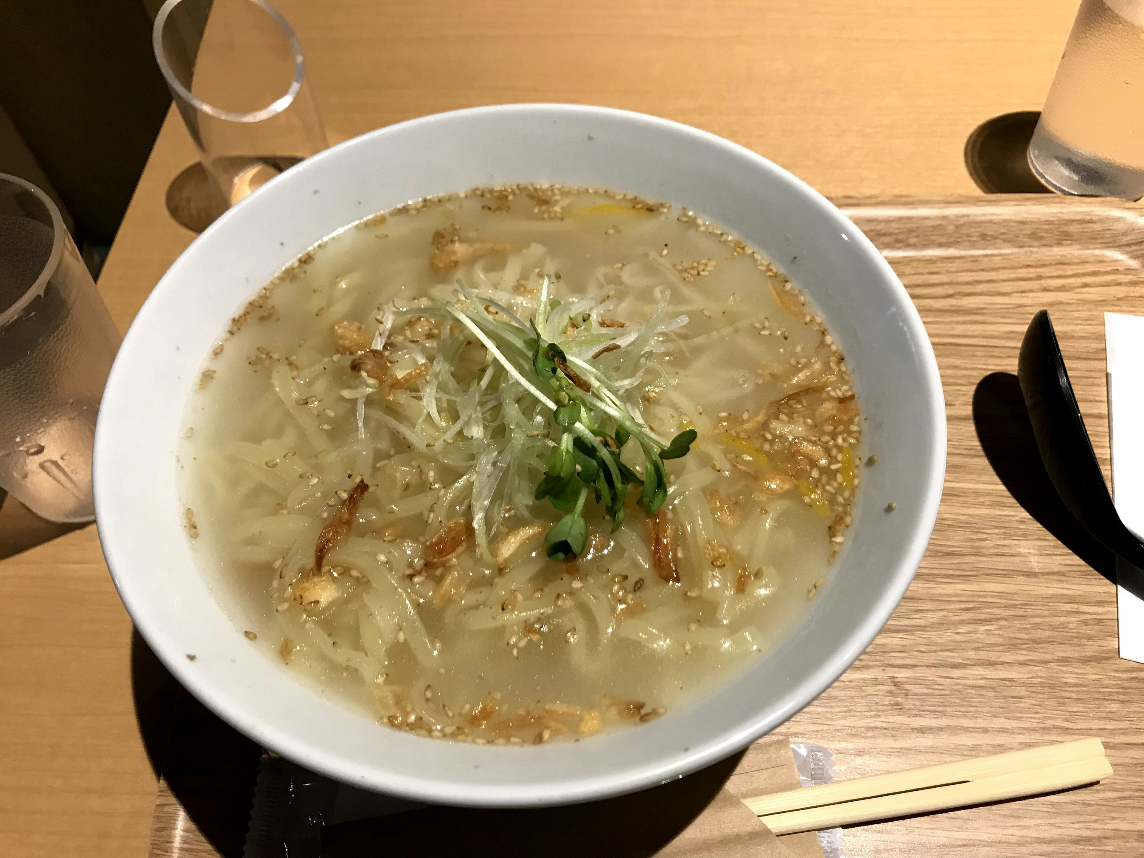 Bowl of ramen with clear broth and shredded vegetables