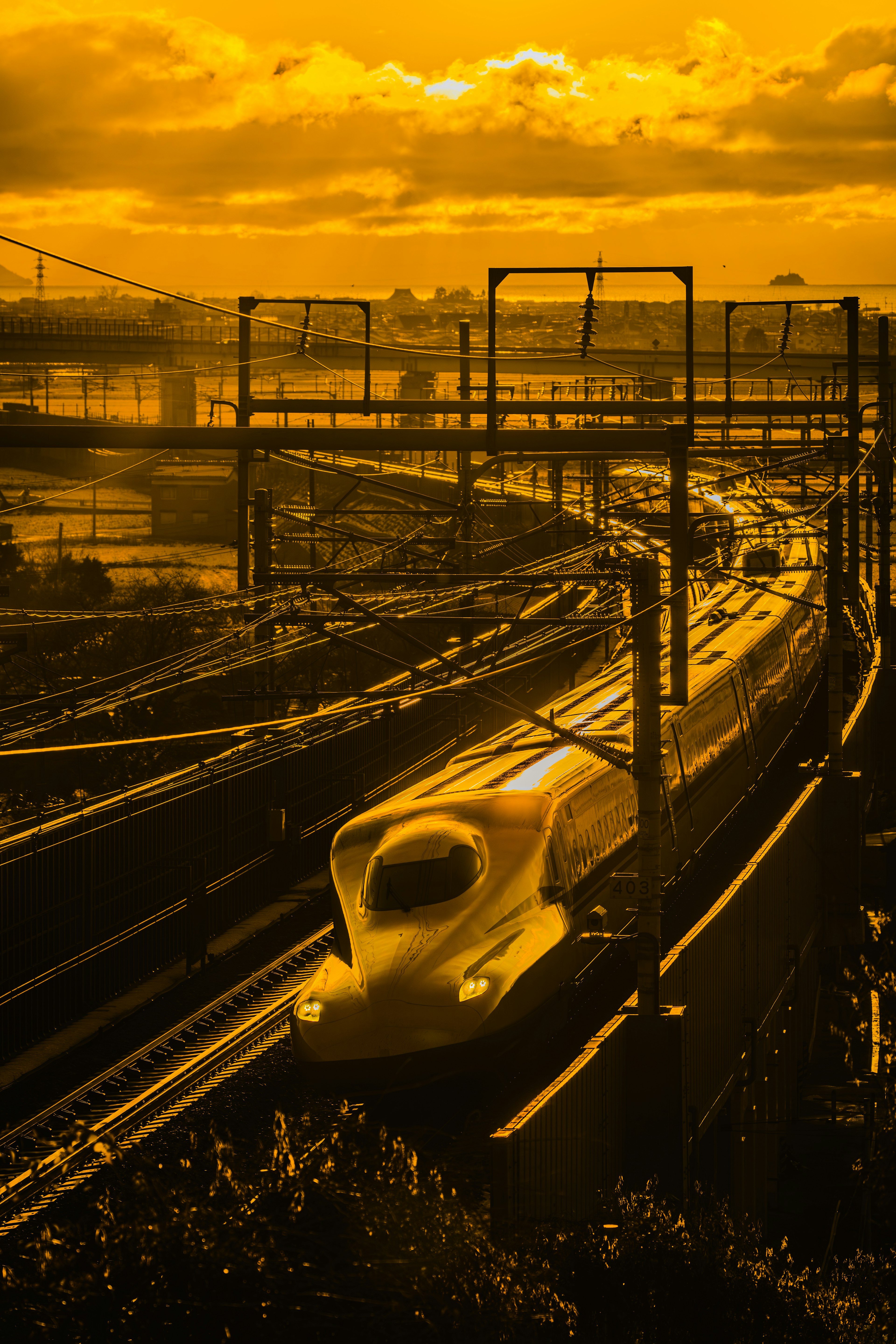 Shinkansen traversant un coucher de soleil aux teintes orange vif