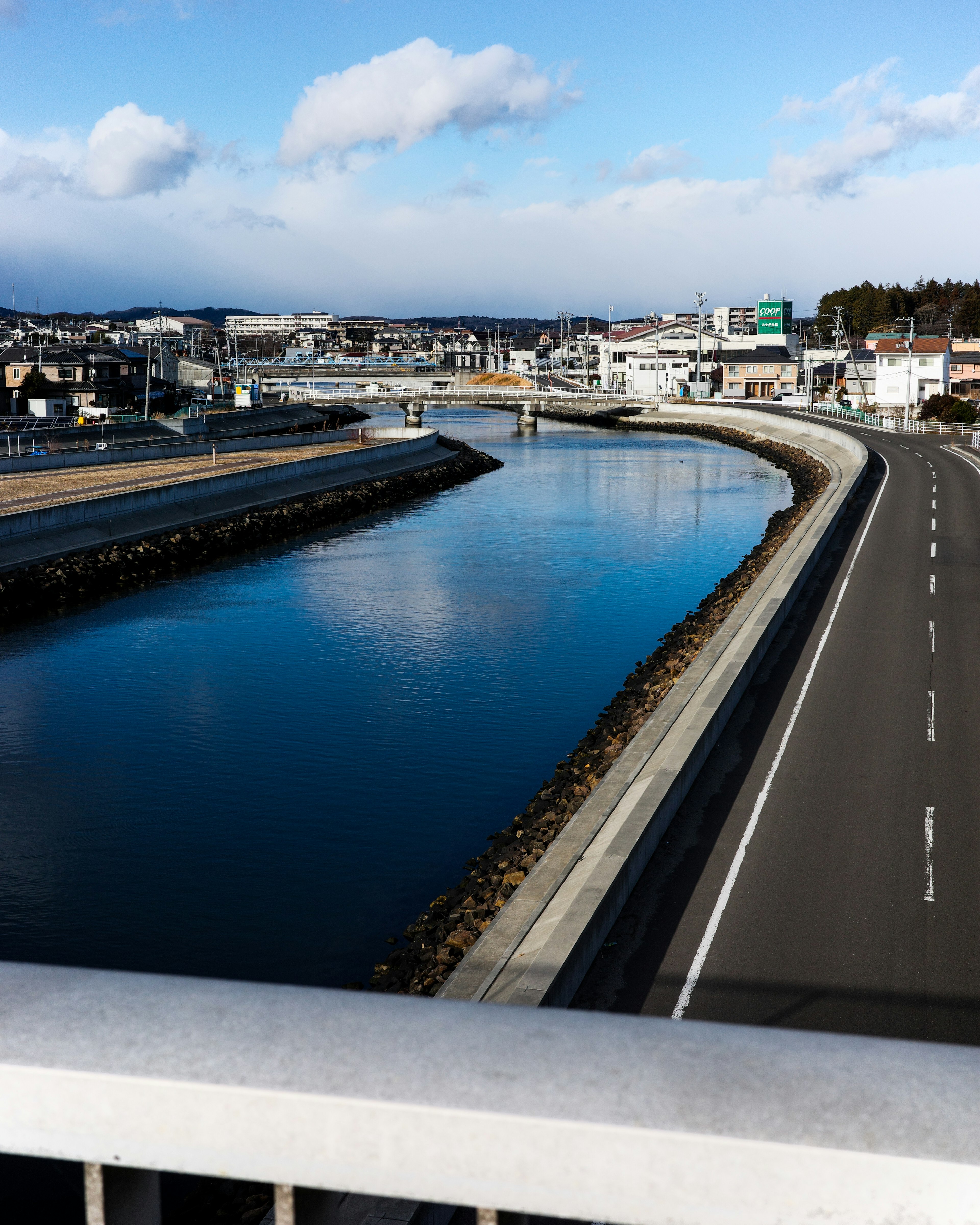 青空の下に流れる川と周囲の街並み