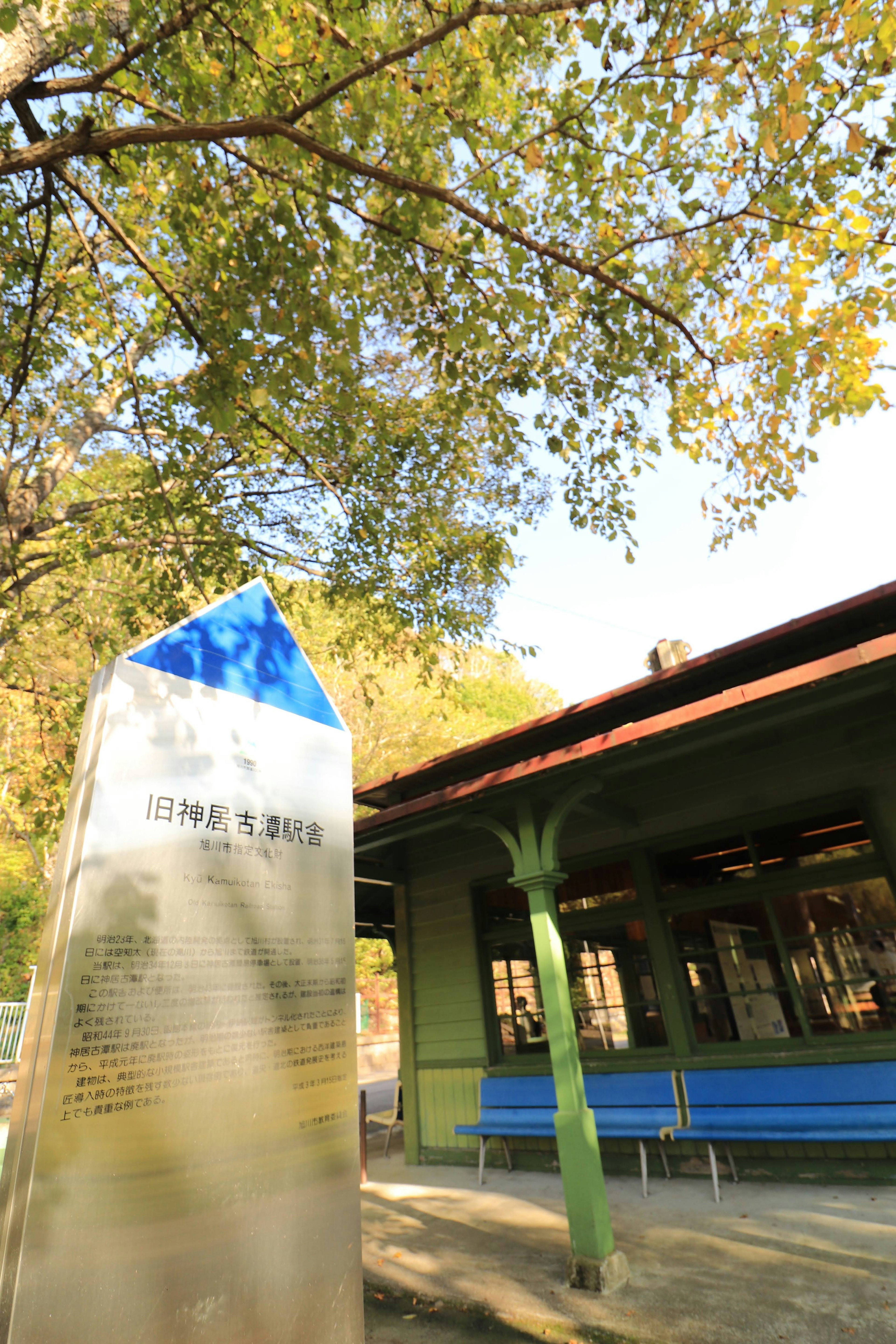 Park scene featuring a blue-roofed building and a monument