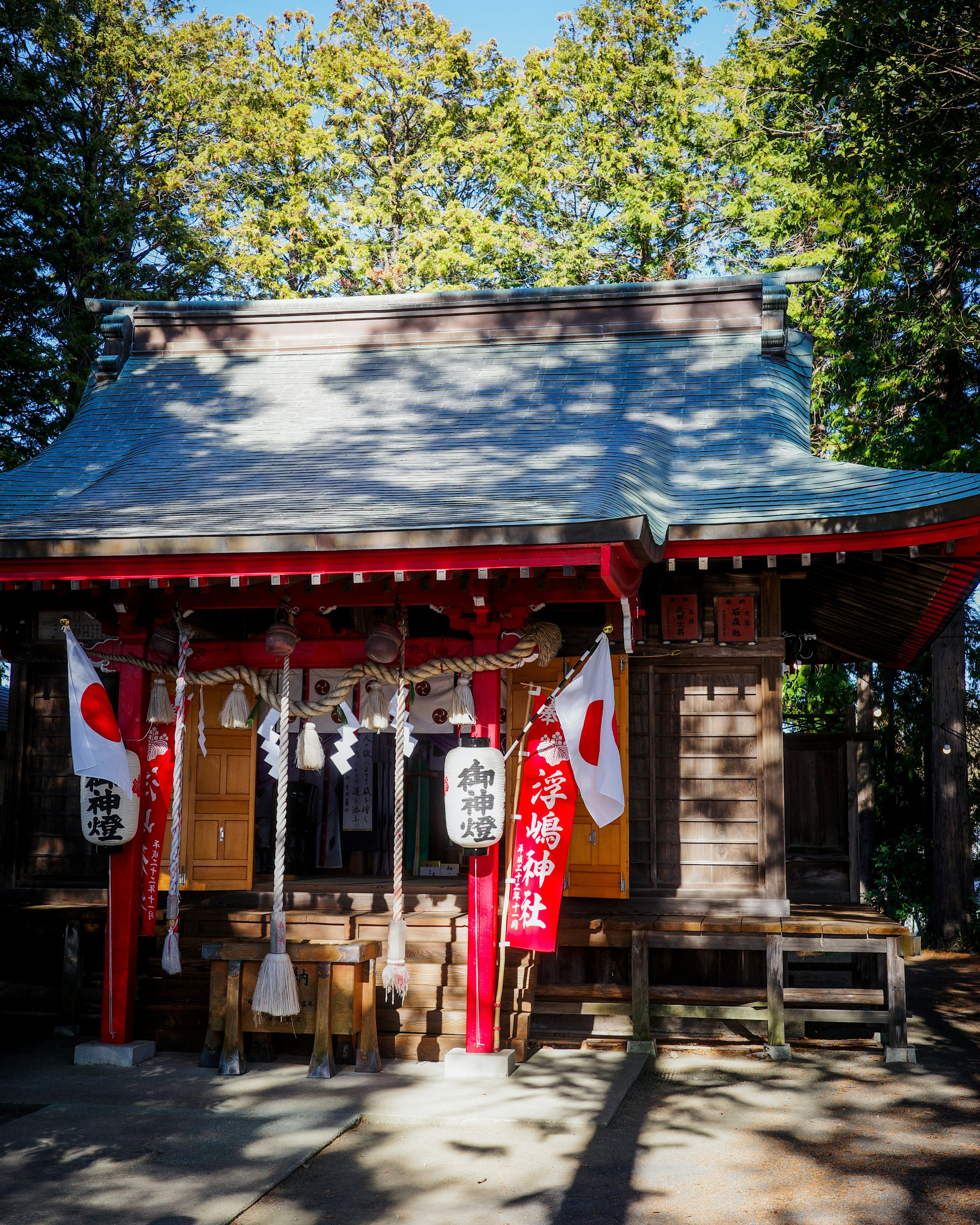 赤い柱と神社の旗がある伝統的な日本の神社の建物